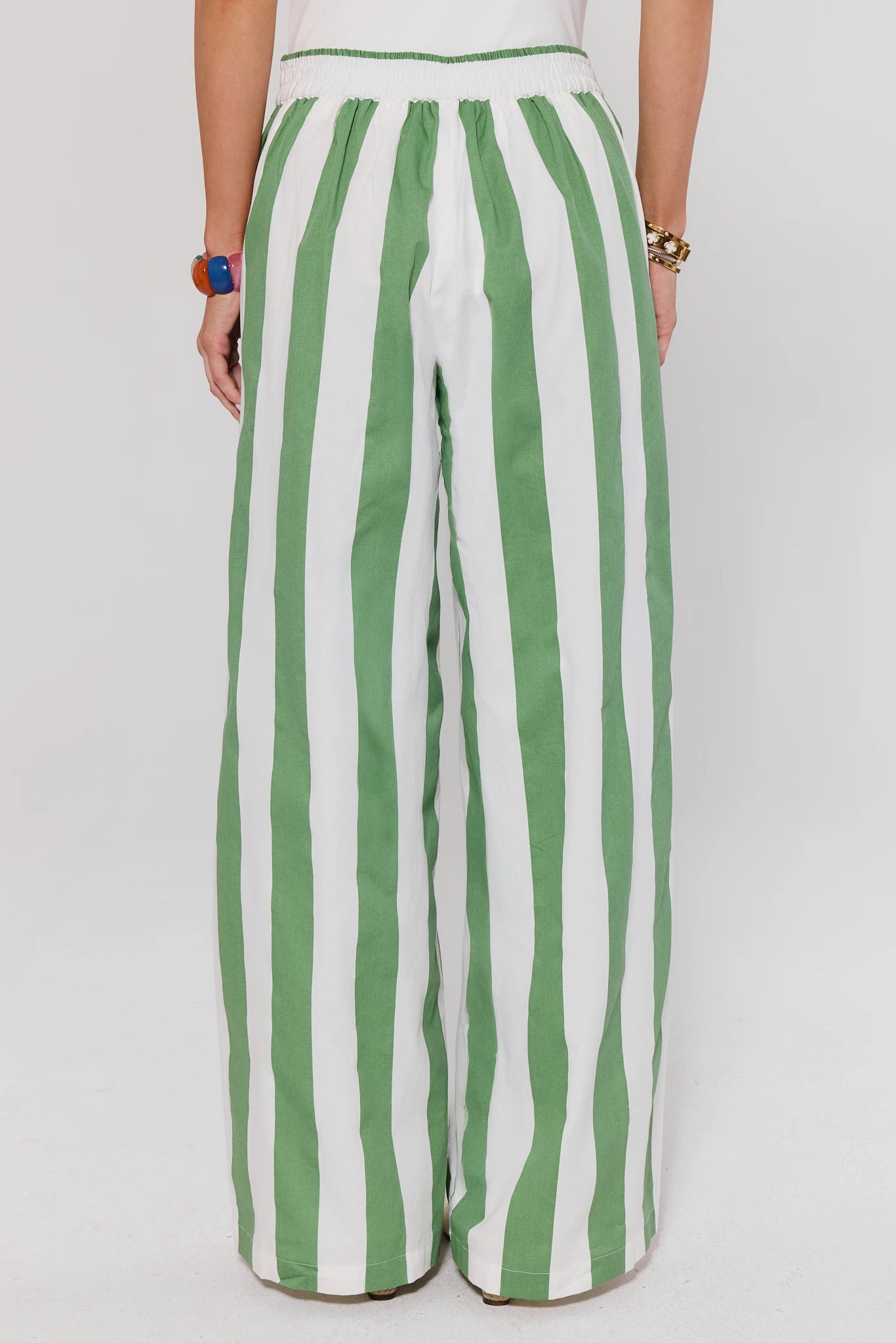 Green and white striped pants on a plain background standing