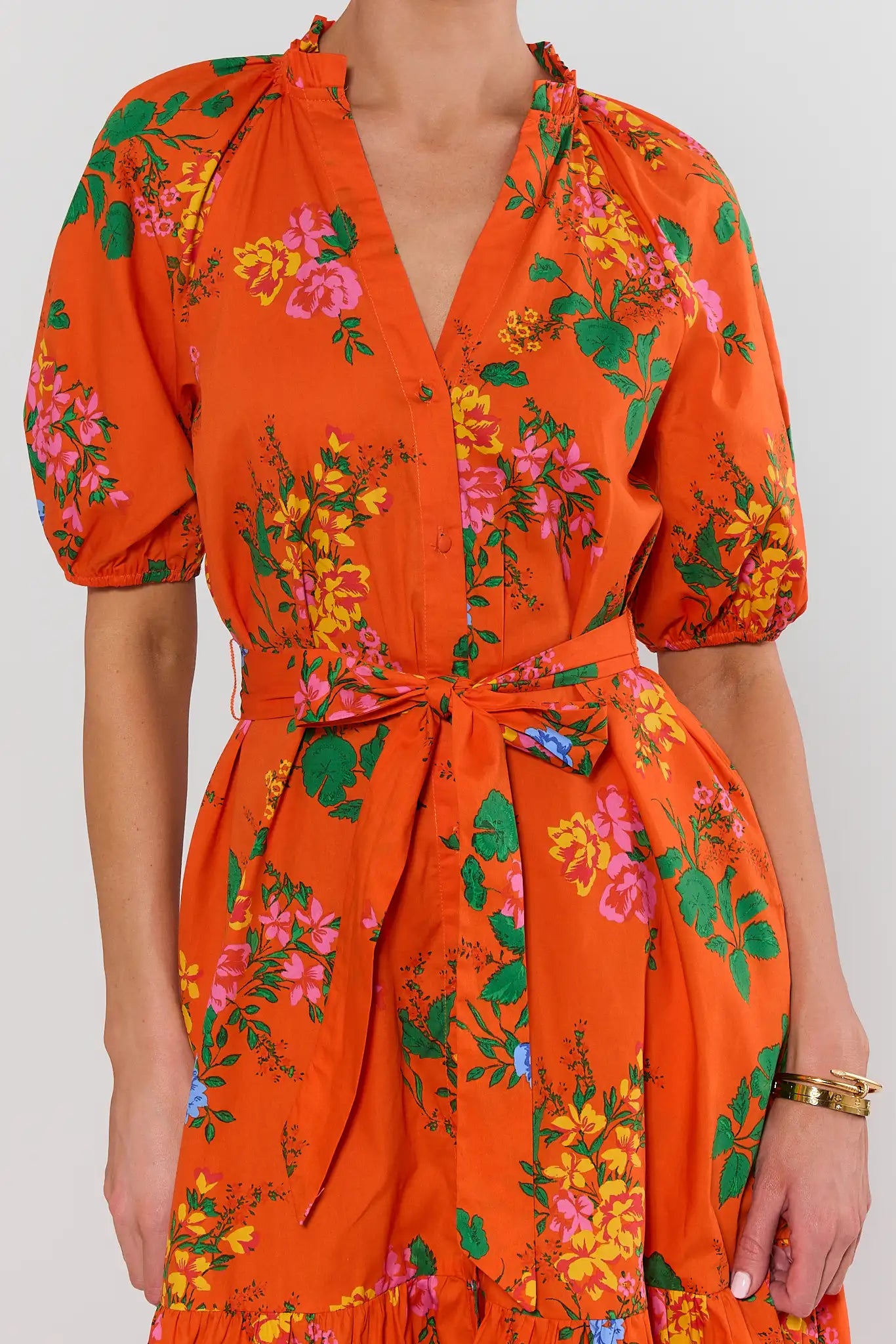 Orange floral dress worn by a person on a white background close up 