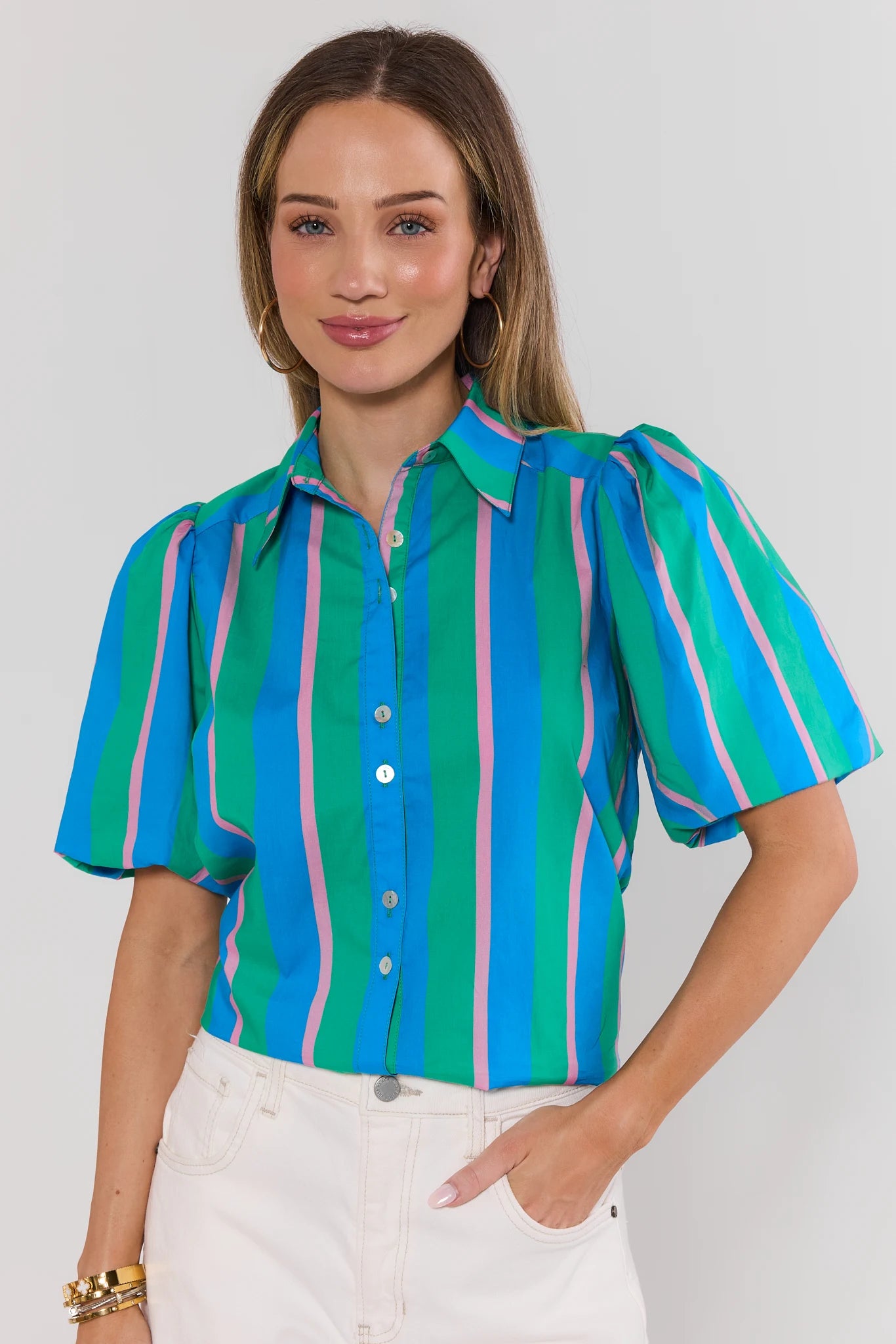 Woman wearing a colorful striped shirt against a plain background