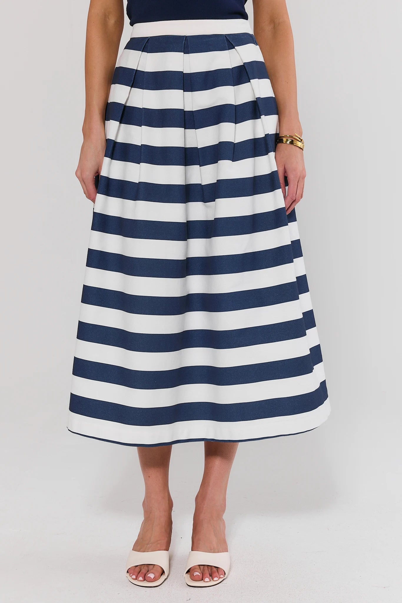 Person wearing a navy and white striped skirt on a plain background