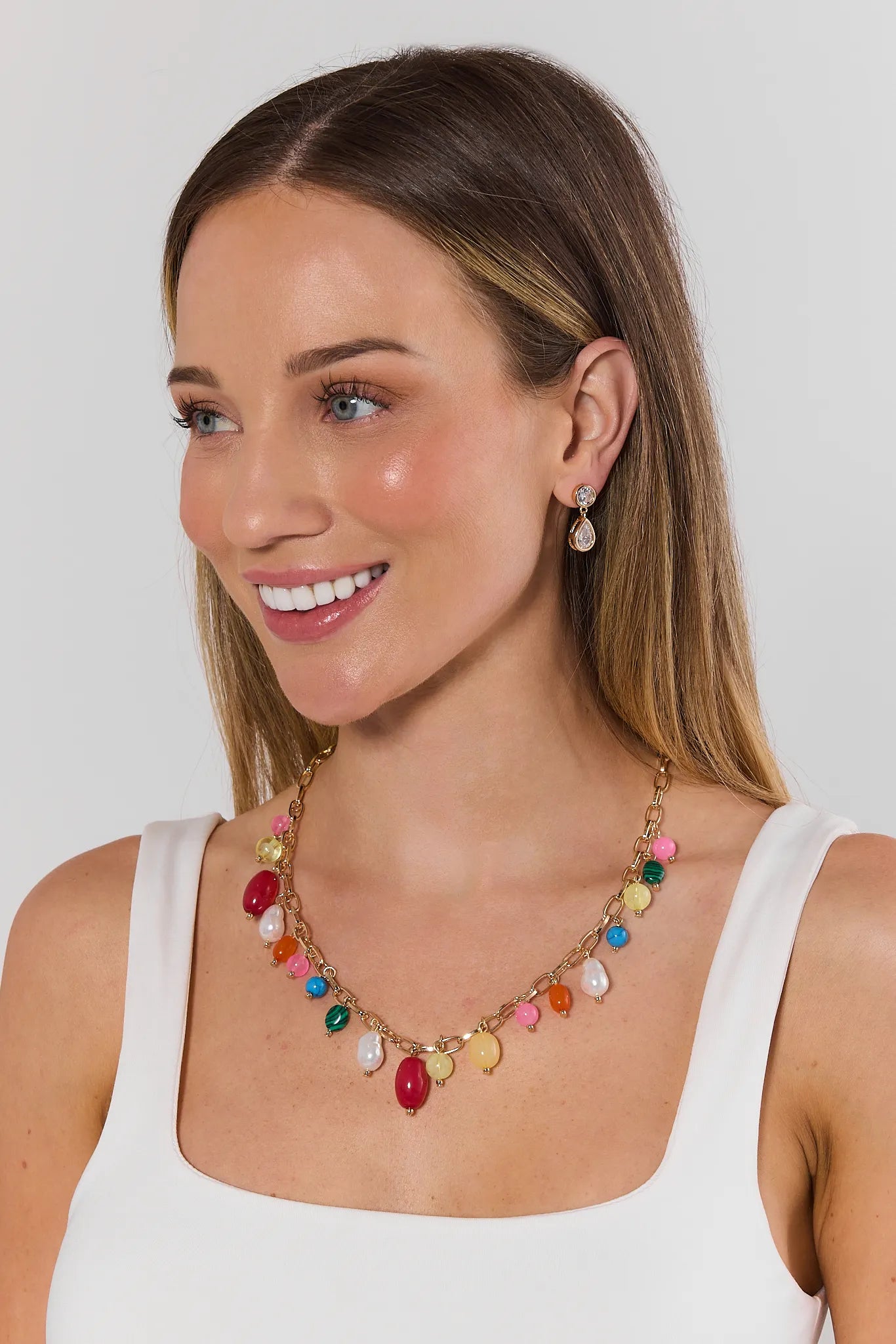 Woman wearing a colorful necklace and earrings on a white background