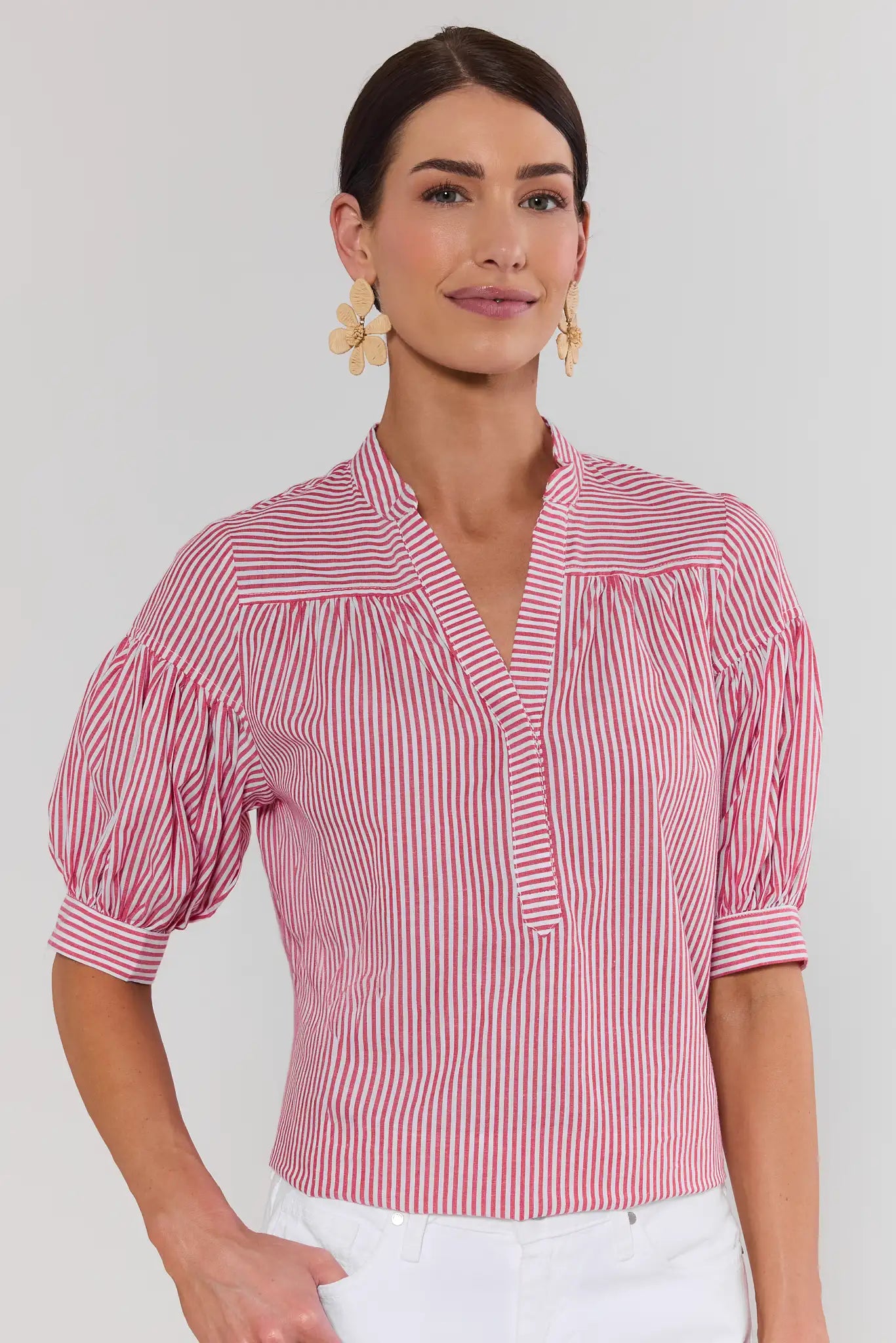Woman wearing a red and white striped blouse against a plain background