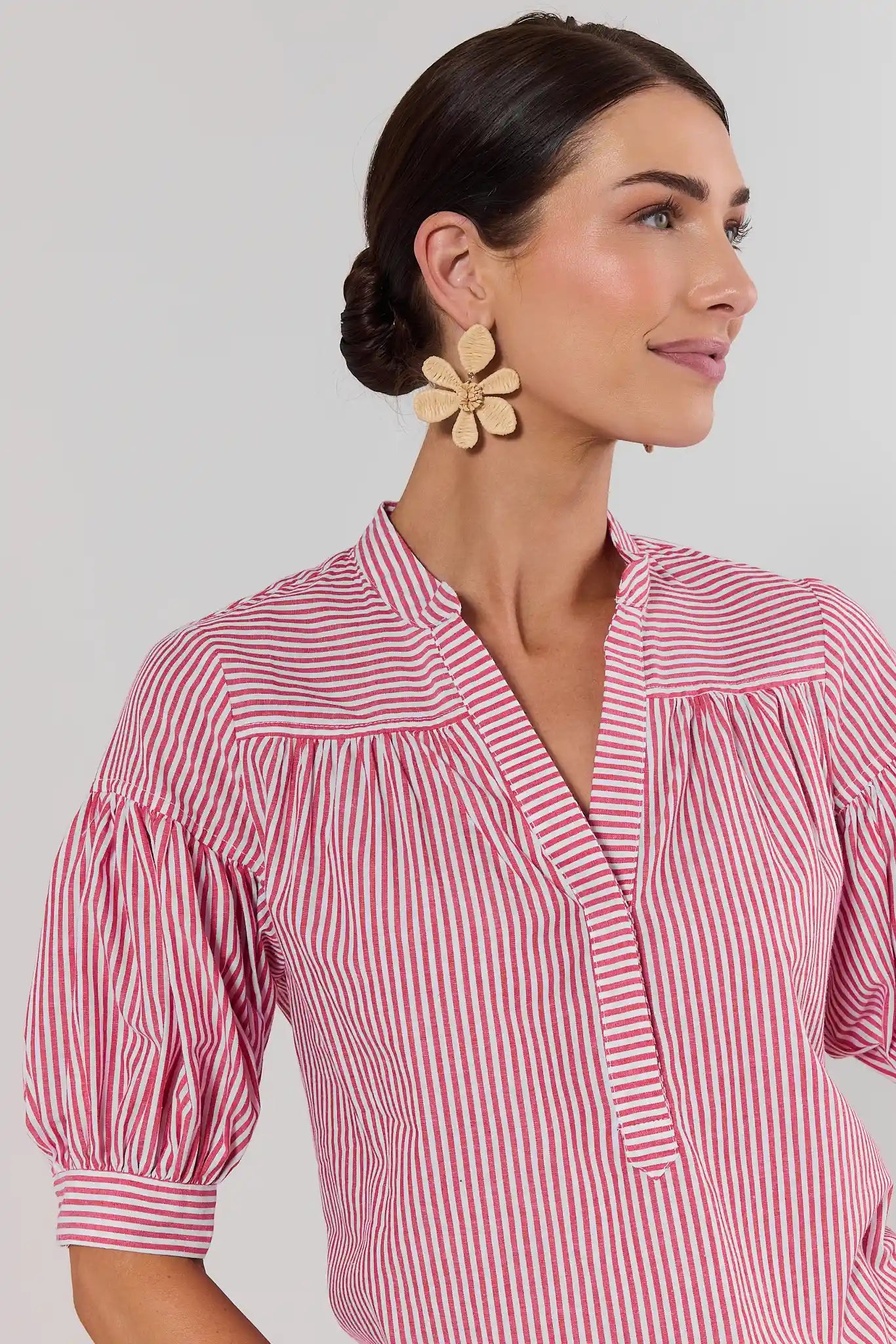 close up Woman wearing a red and white striped shirt with a neutral background
