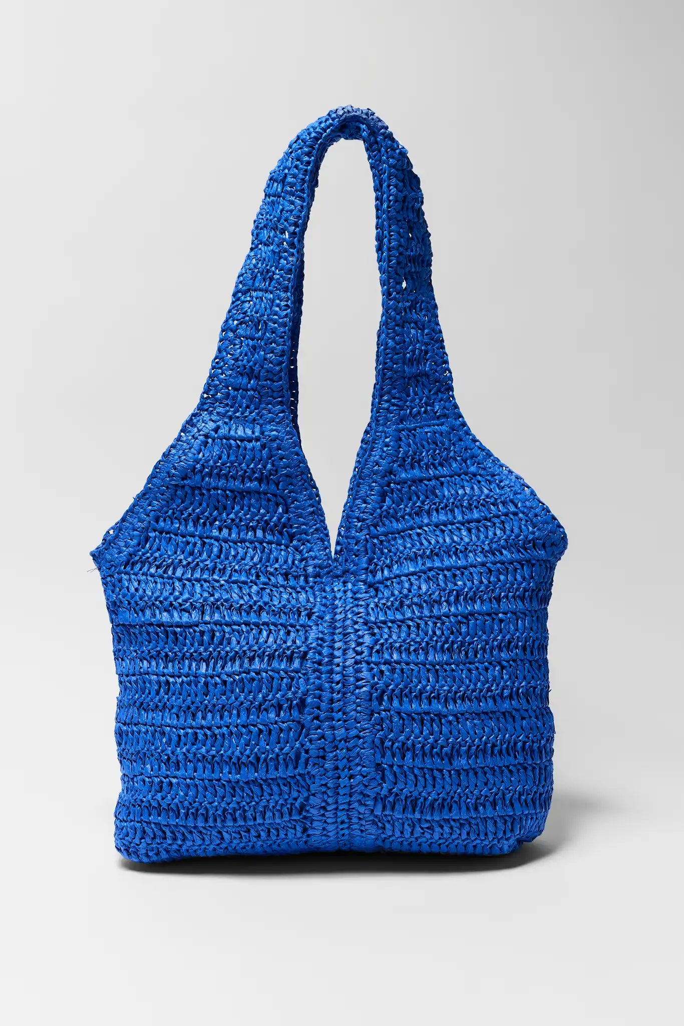 blue woven bag on white background