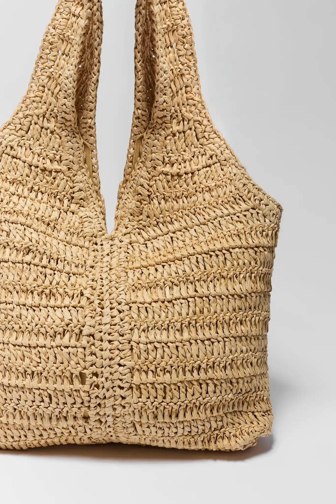 Woven straw bag on a light gray background close up