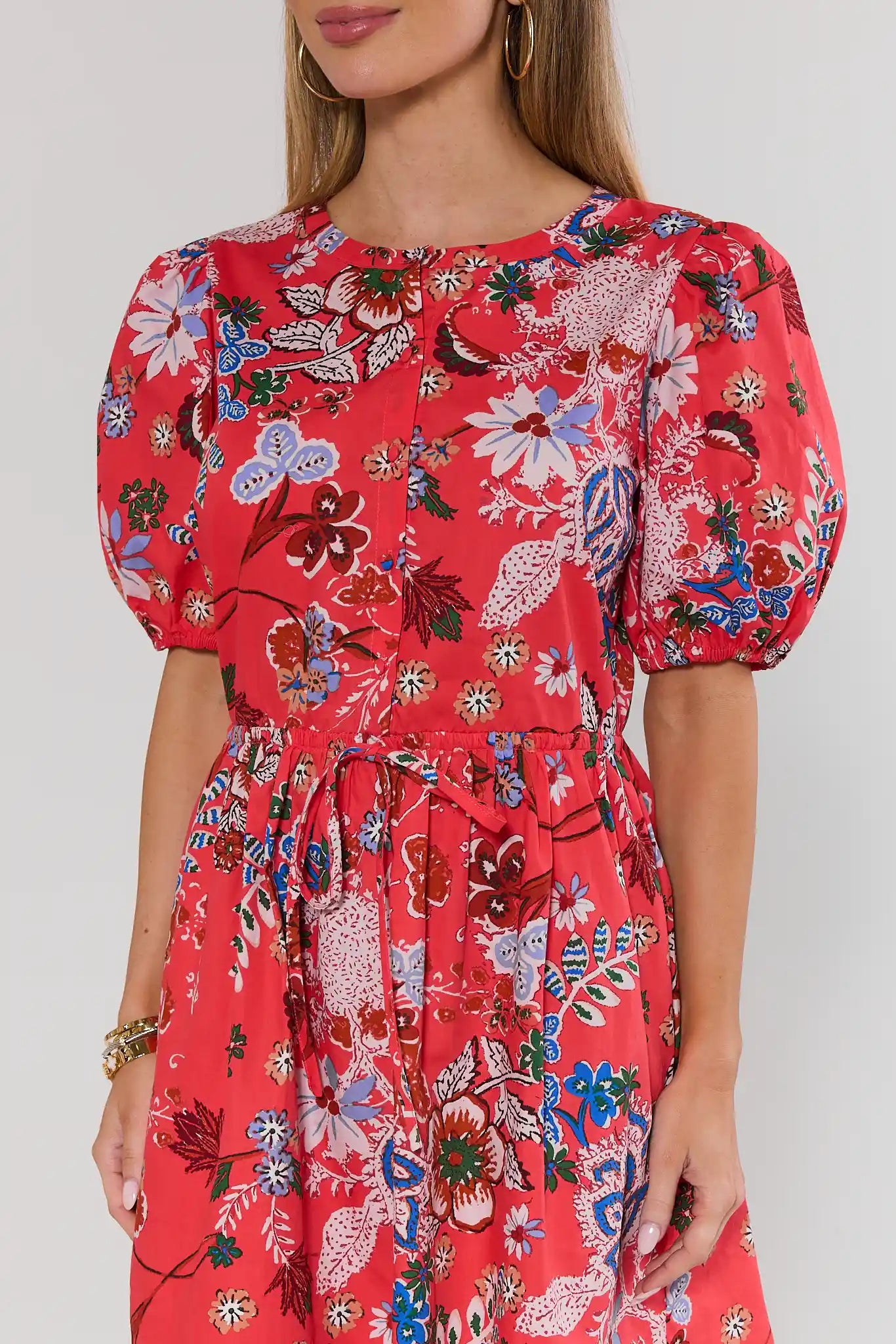 coral floral dress with puff sleeves on a plain background close up