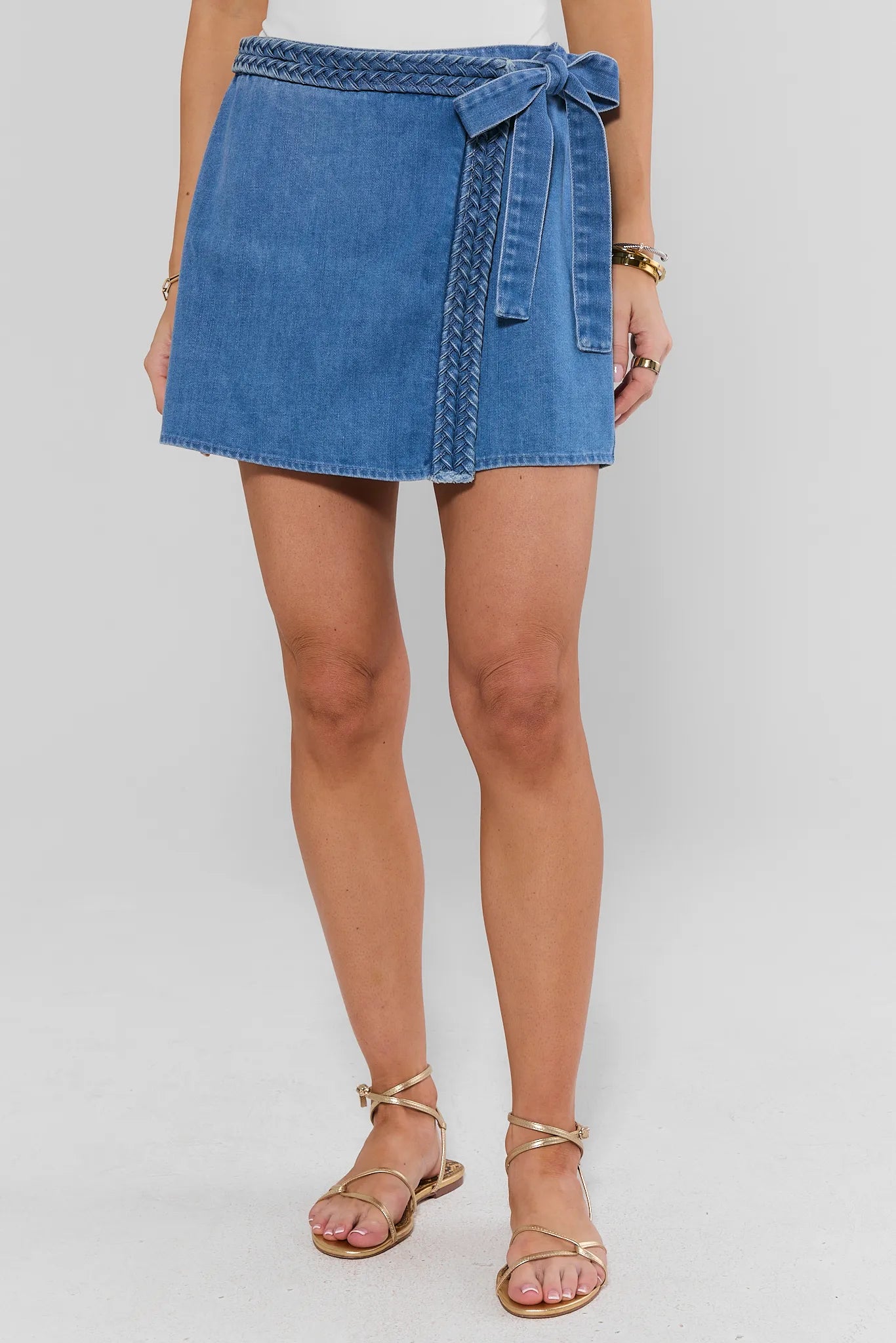 Person wearing a farrah blue denim skirt on a plain background
