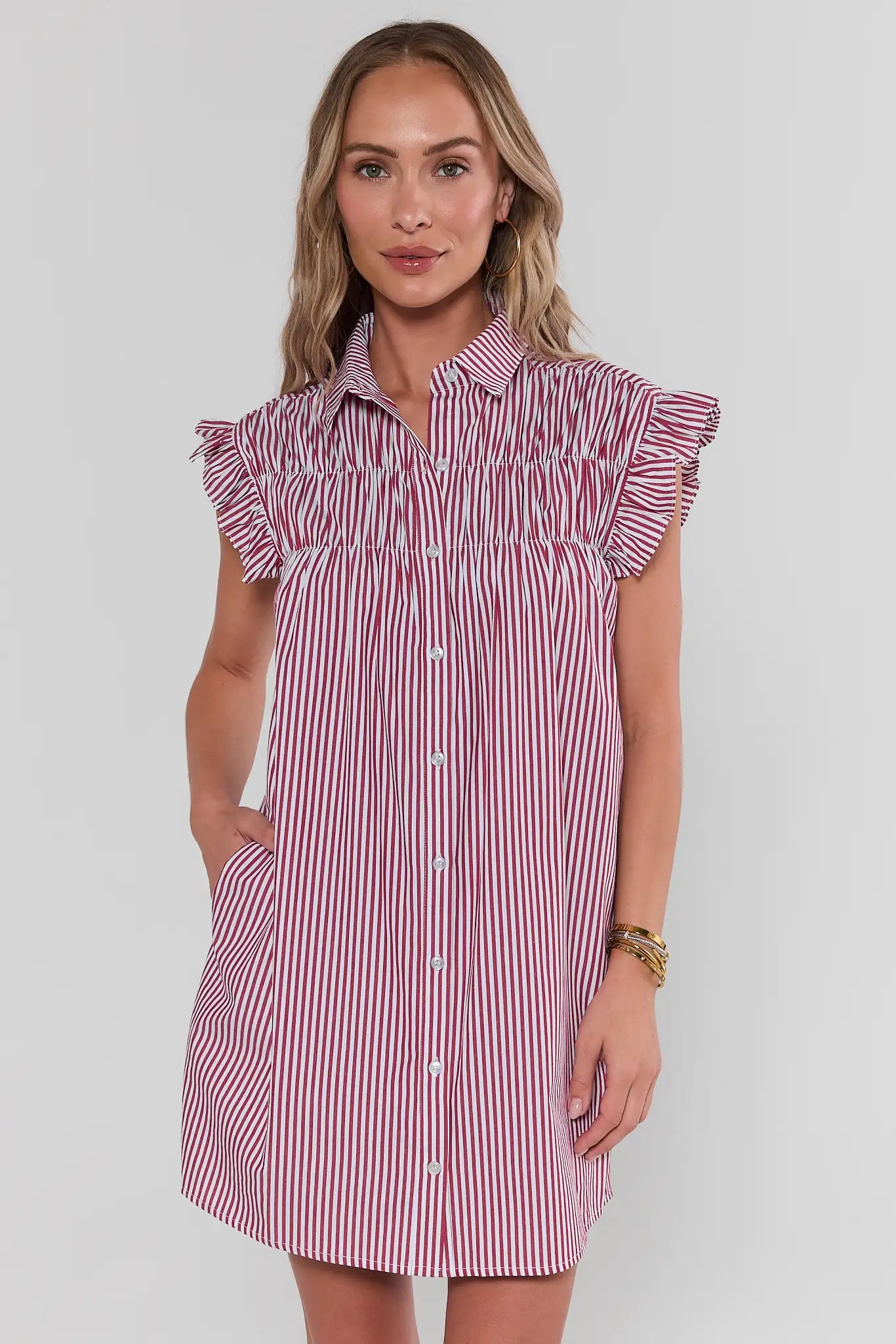 Woman wearing a red and white striped dress against a plain background