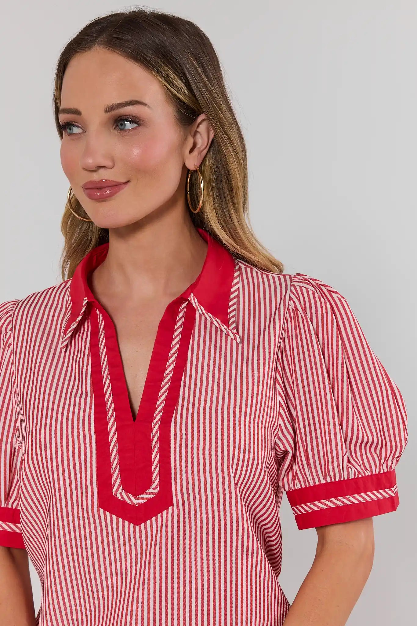close up Woman wearing a red and white striped shirt with a plain background