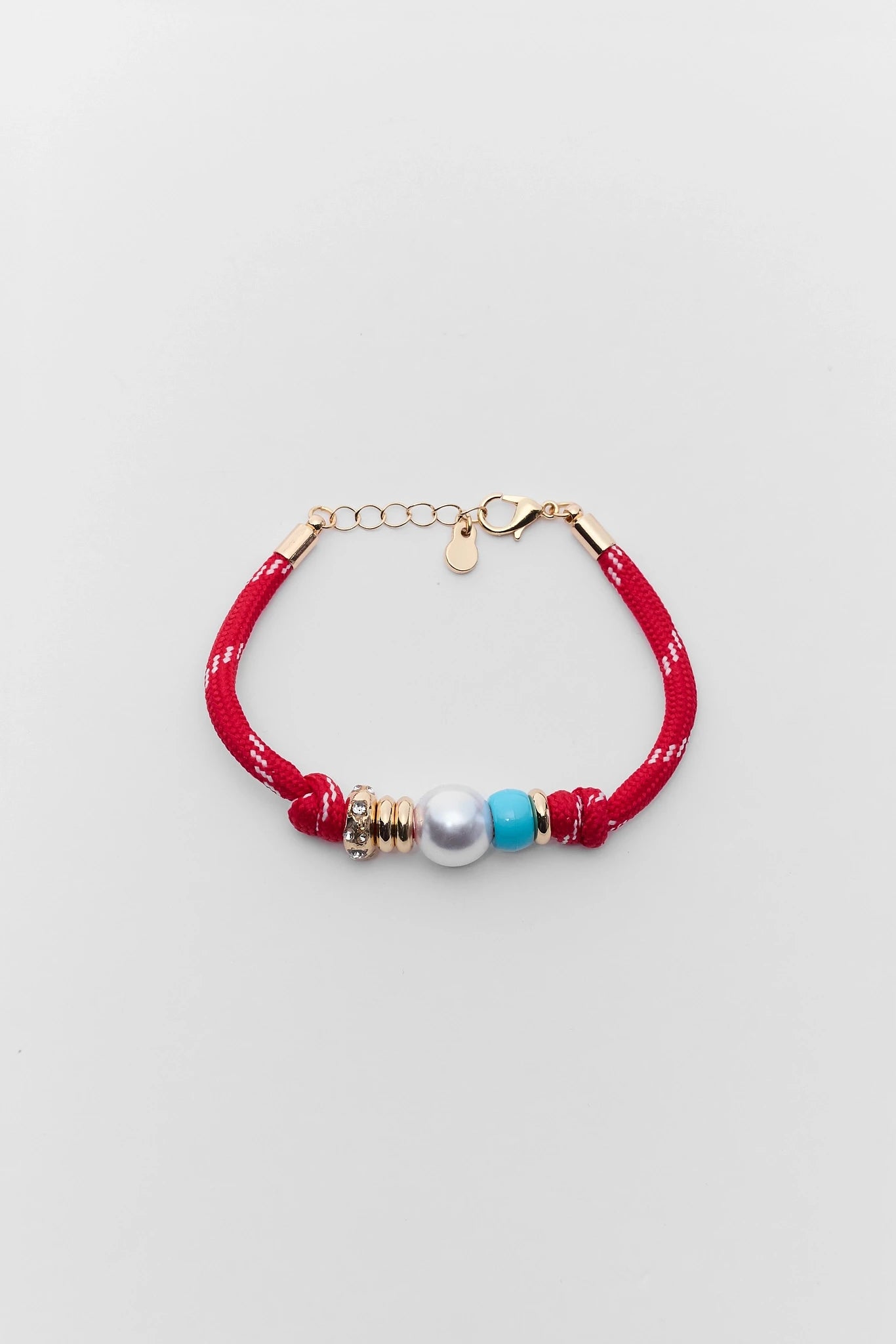 Bracelet with red fabric strap, gold accents, and colorful beads on a light gray background