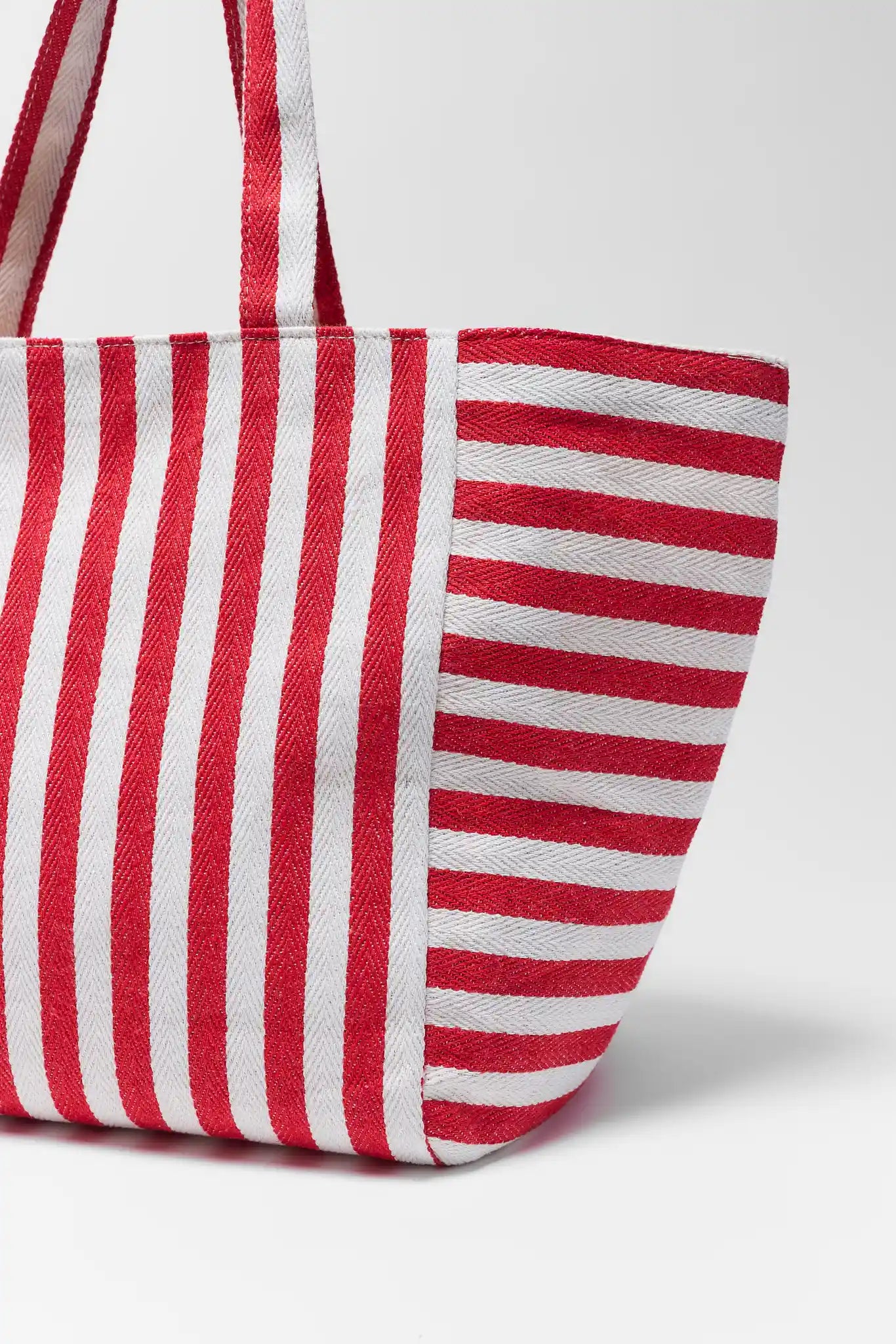 Red and white striped bag on a light gray background close up