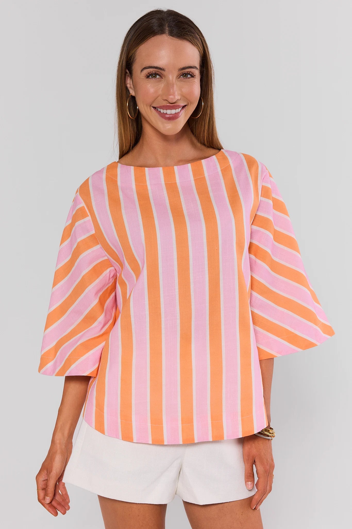 Woman wearing a colorful striped shirt with a plain background