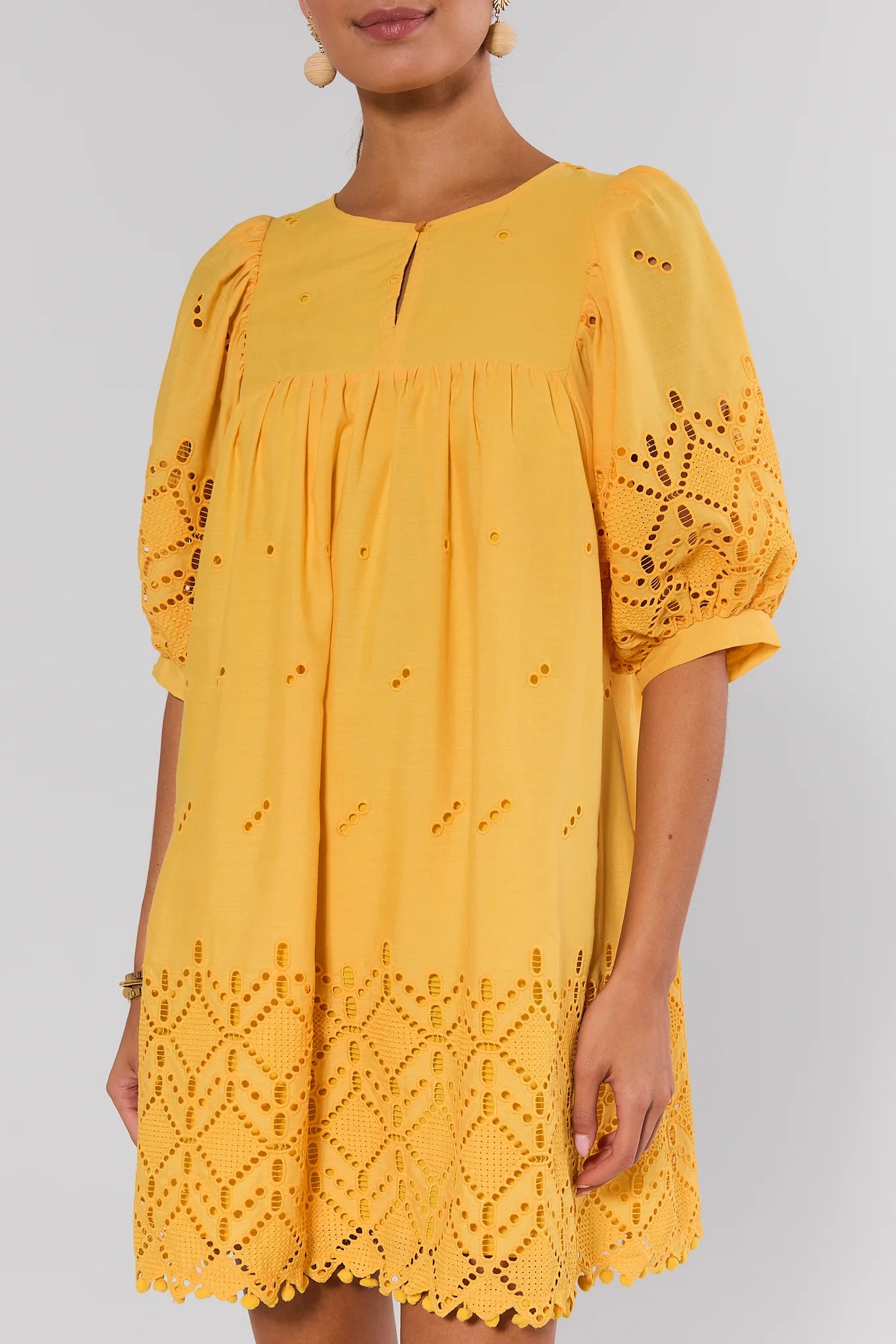 Yellow dress with lace details on a plain background close up