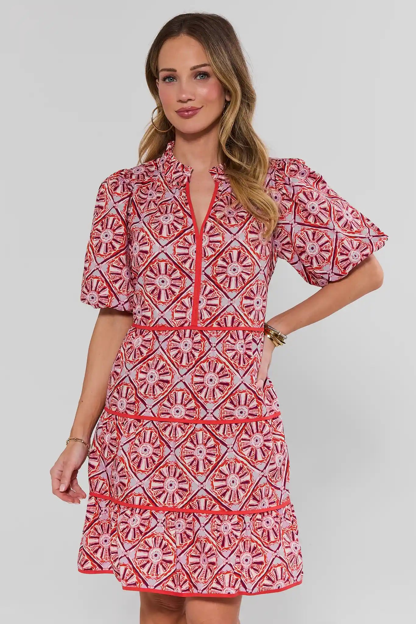Woman wearing a red and white patterned dress on a plain background