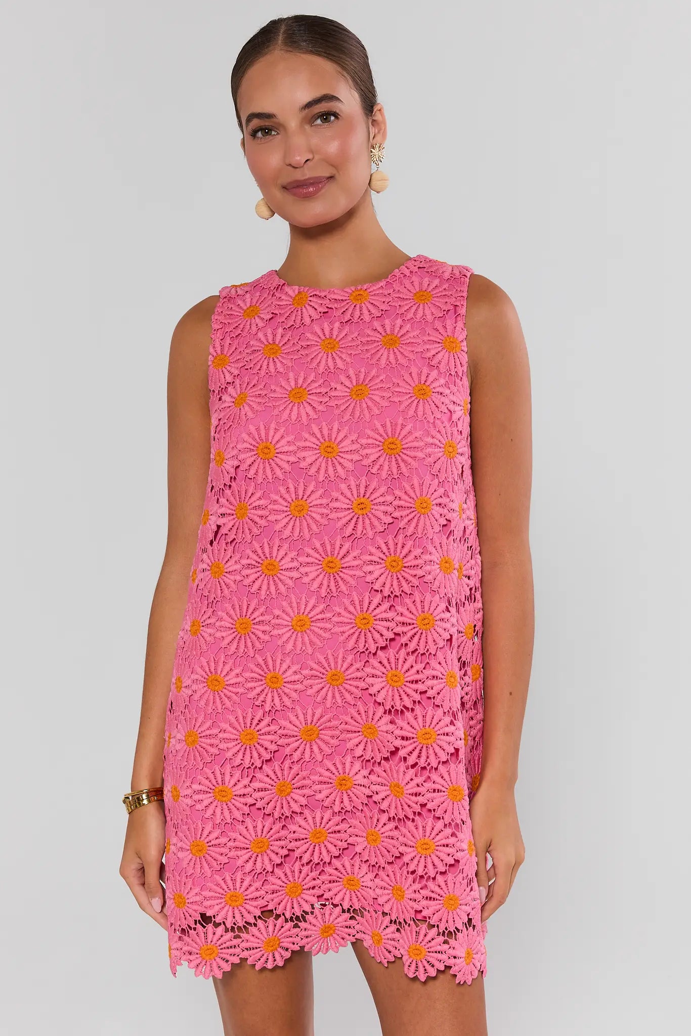 Woman wearing a pink dress with floral pattern on a plain background