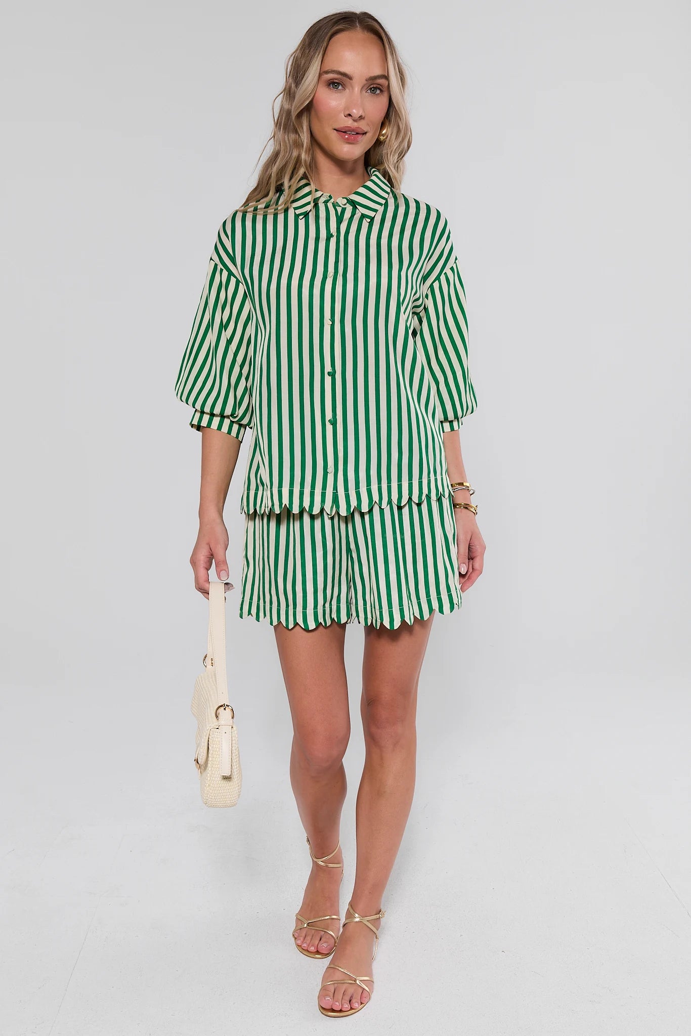 Woman wearing a green and white striped outfit on a plain background