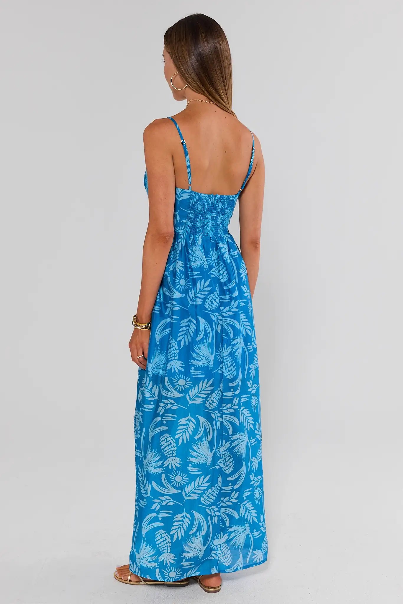 Woman wearing a blue floral dress on a white background walking