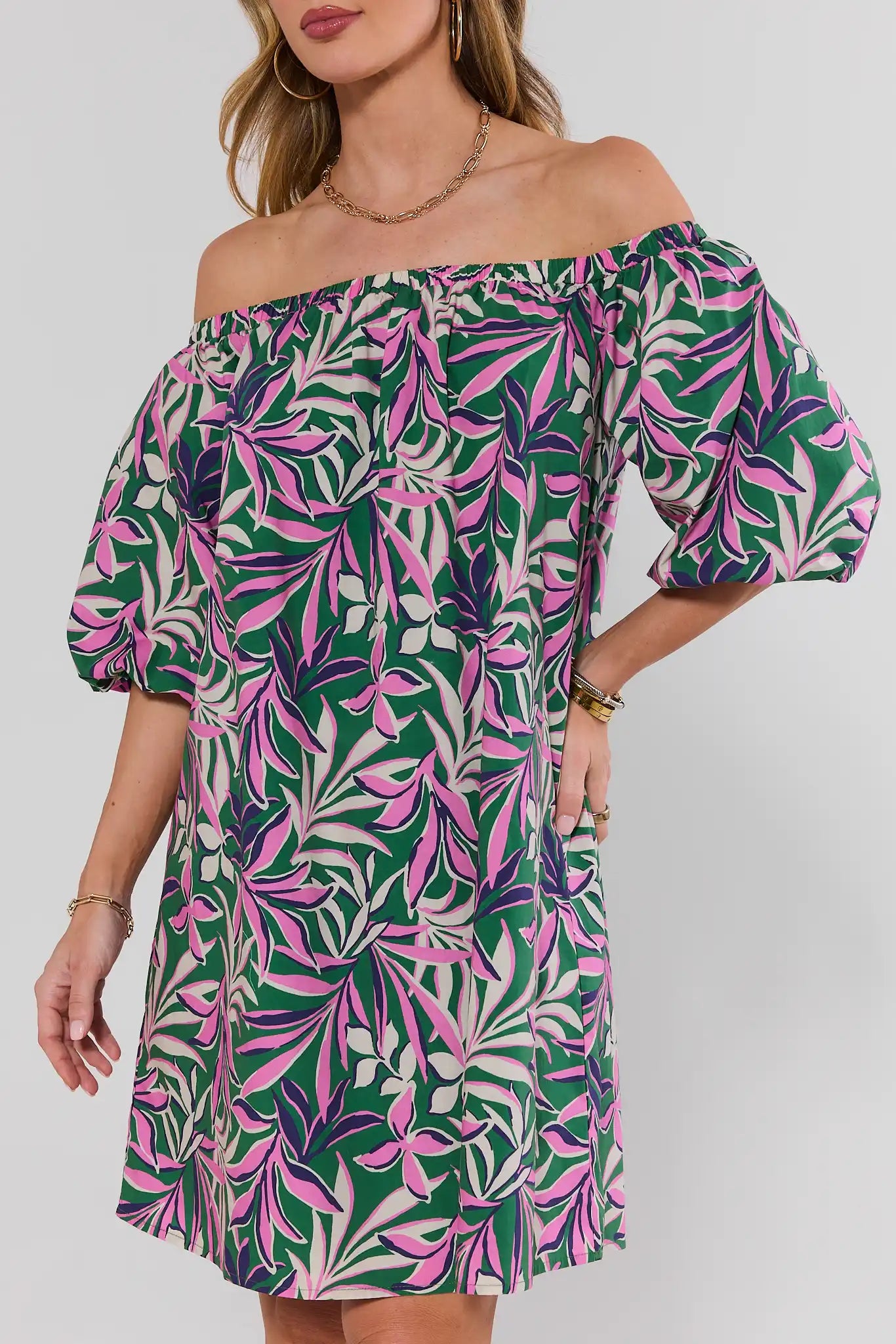 close up Woman wearing a green and pink leaf-patterned dress on a white background