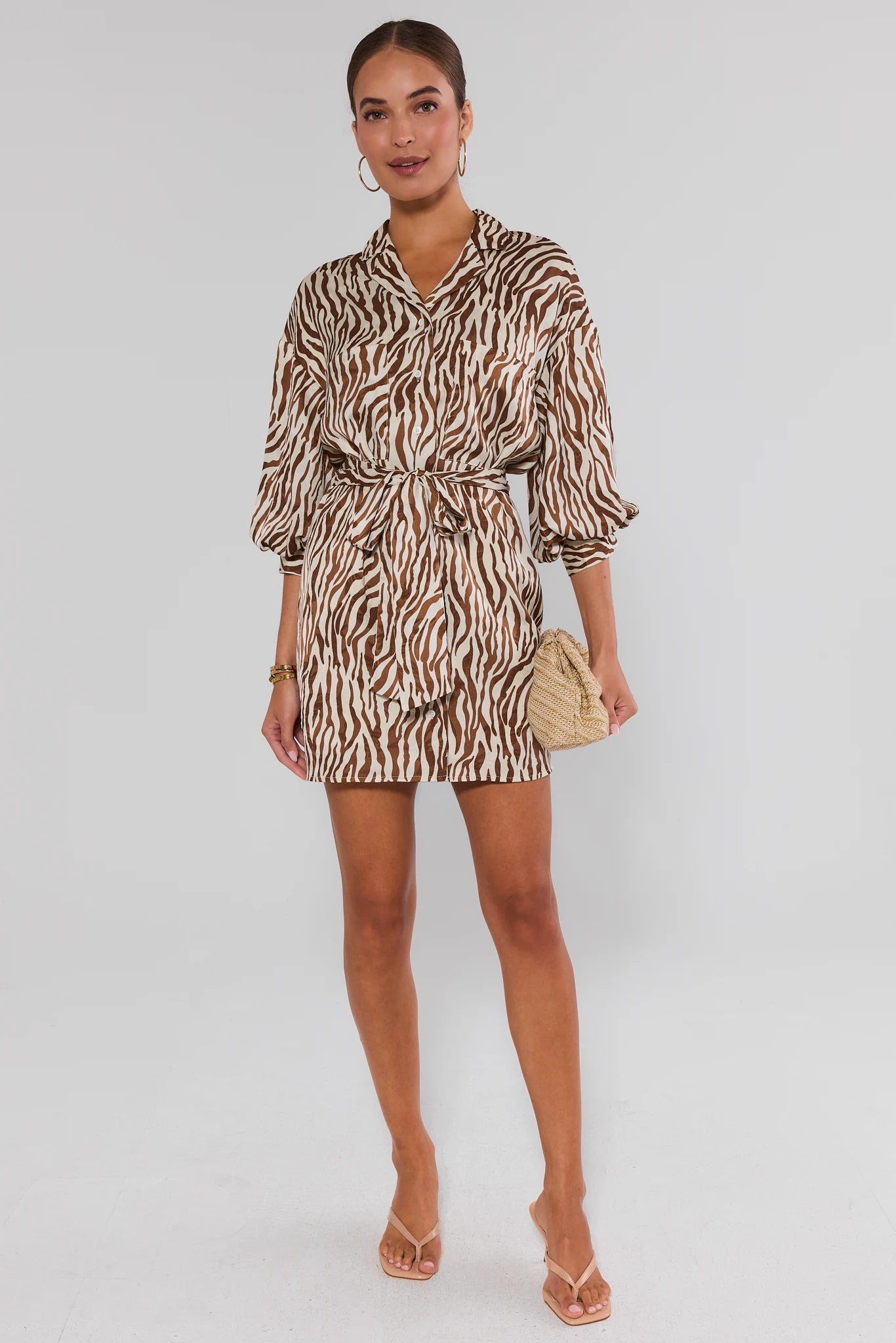 Woman wearing a zebra print dress on a white background standing