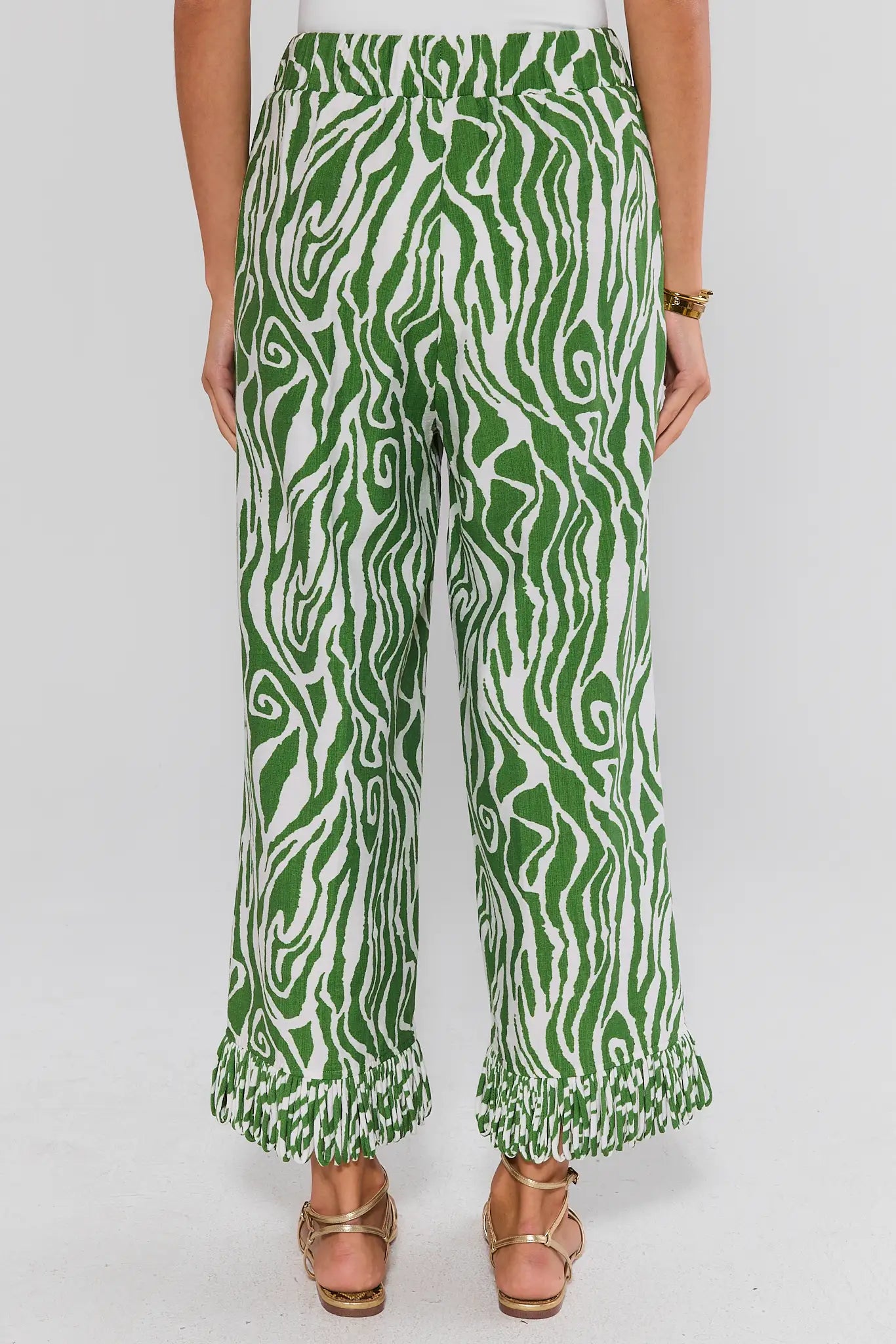 Green and white patterned pants worn by a person on a white background standing