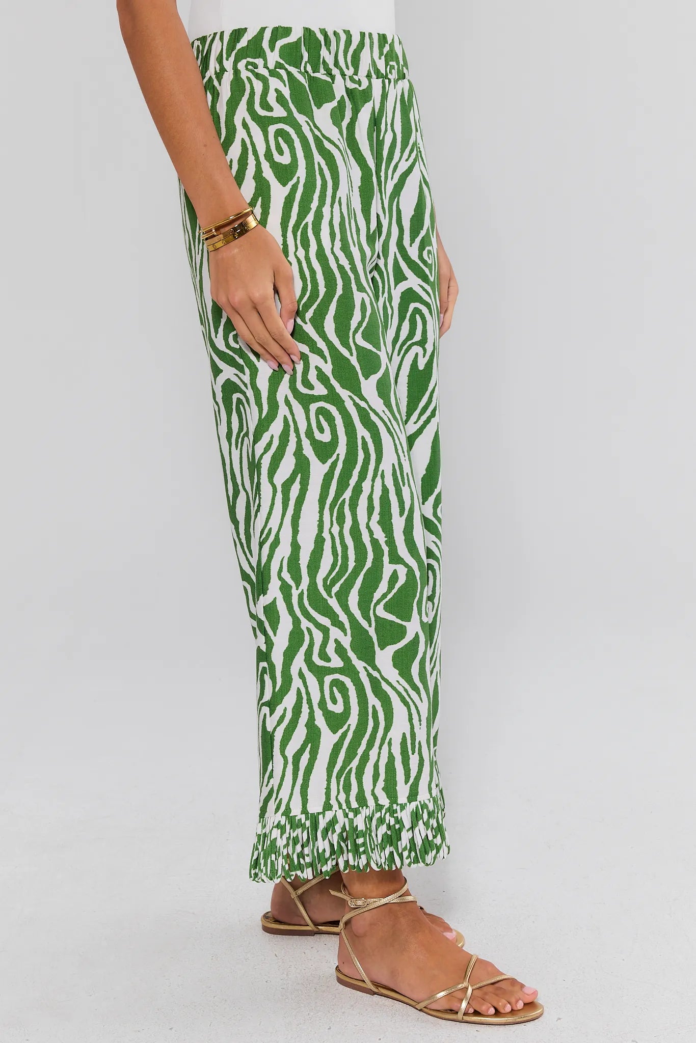 Green and white patterned pants worn by a person on a plain background side