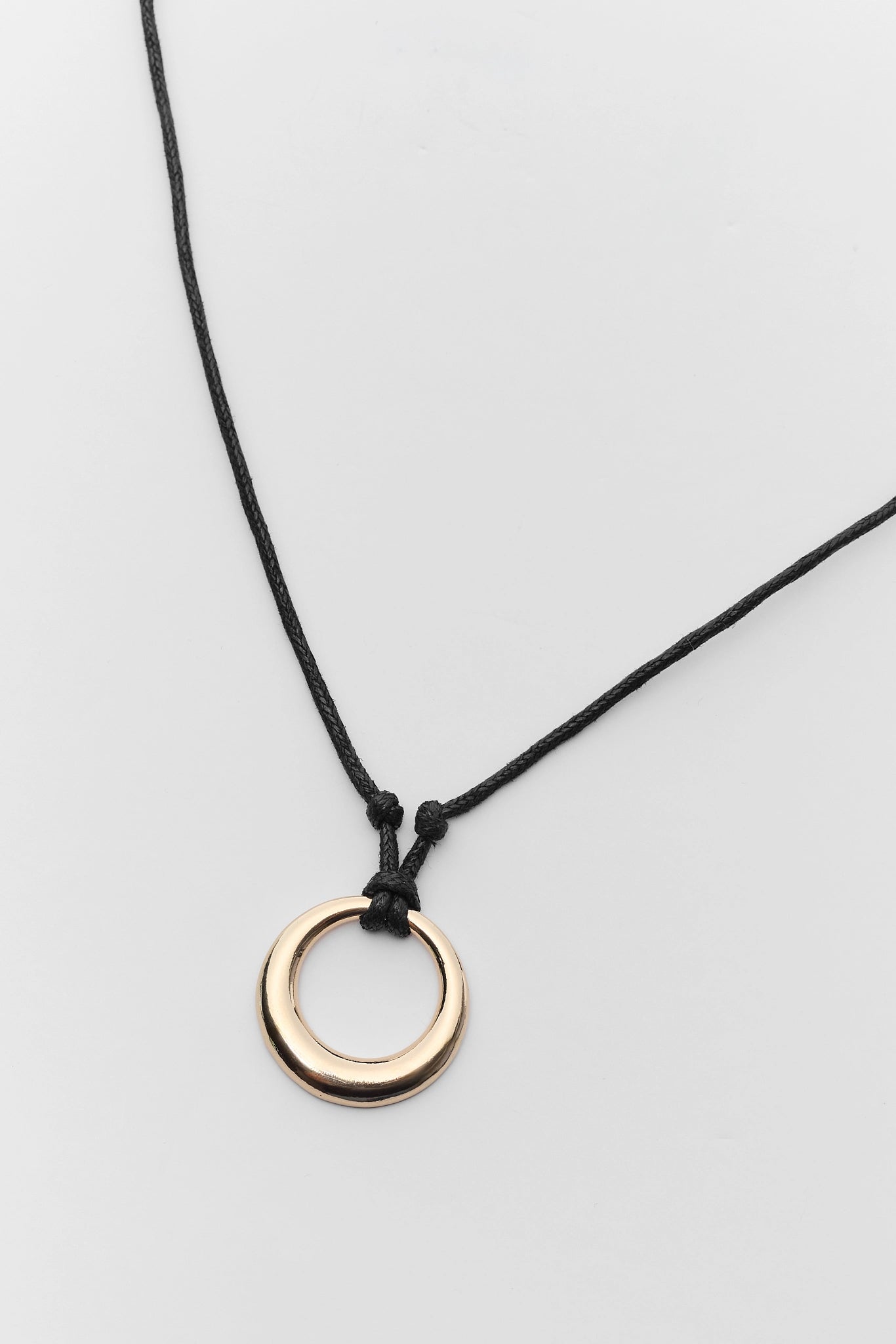 Necklace with a gold ring pendant on a white background close up