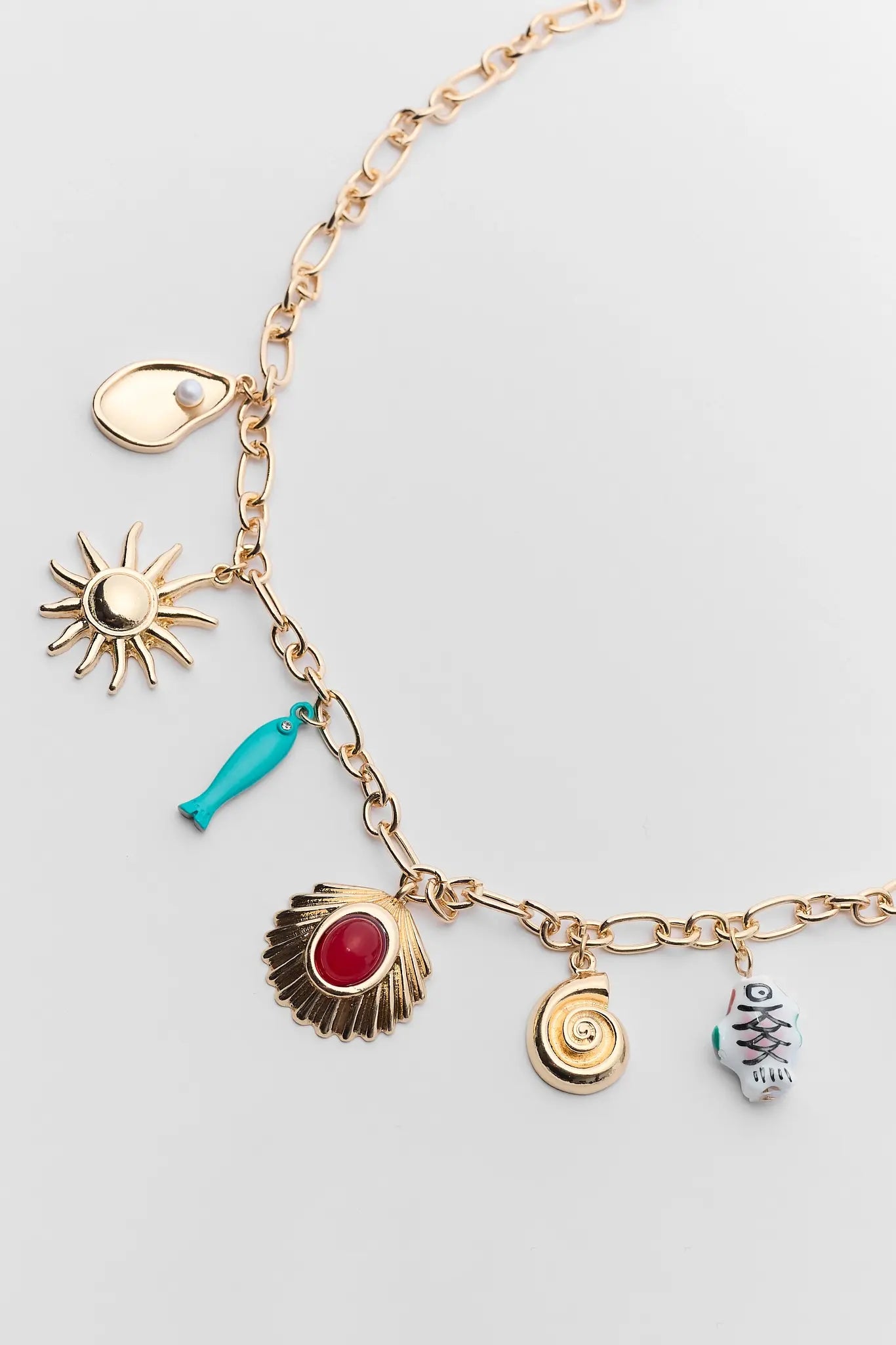 Gold necklace with charms on a gray background