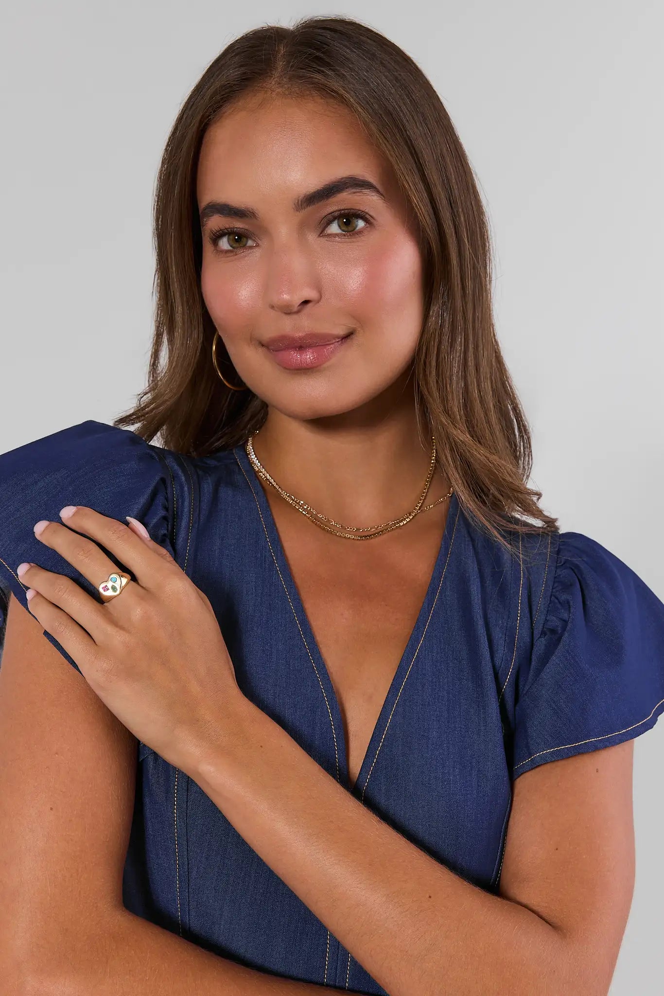 Woman wearing a blue dress and ring with a plain background