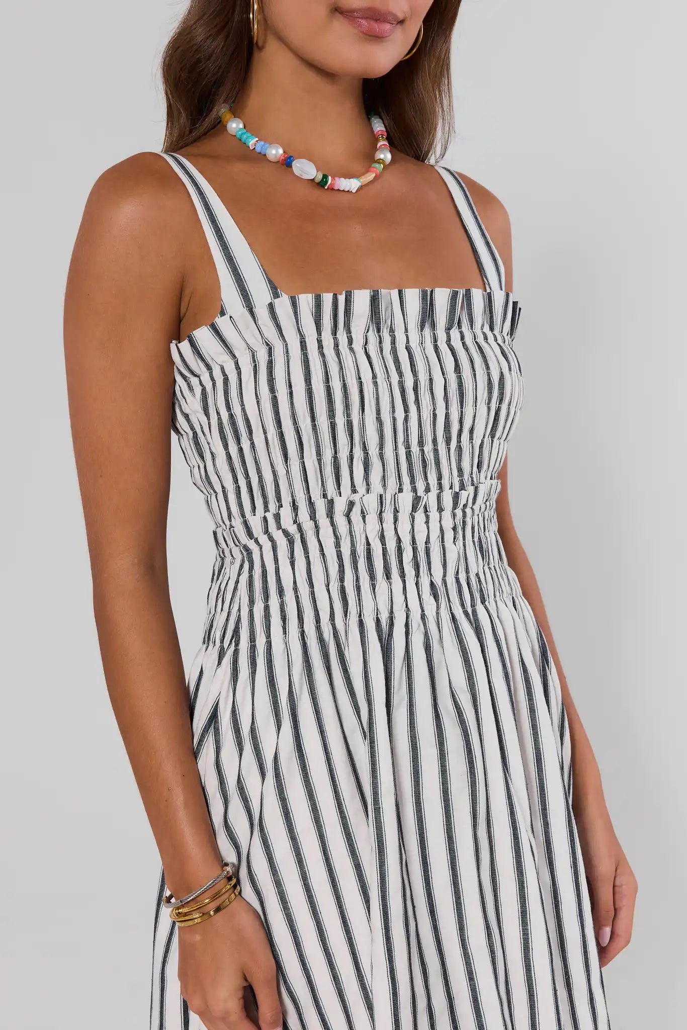 Woman wearing a black and white striped dress on a plain background close up