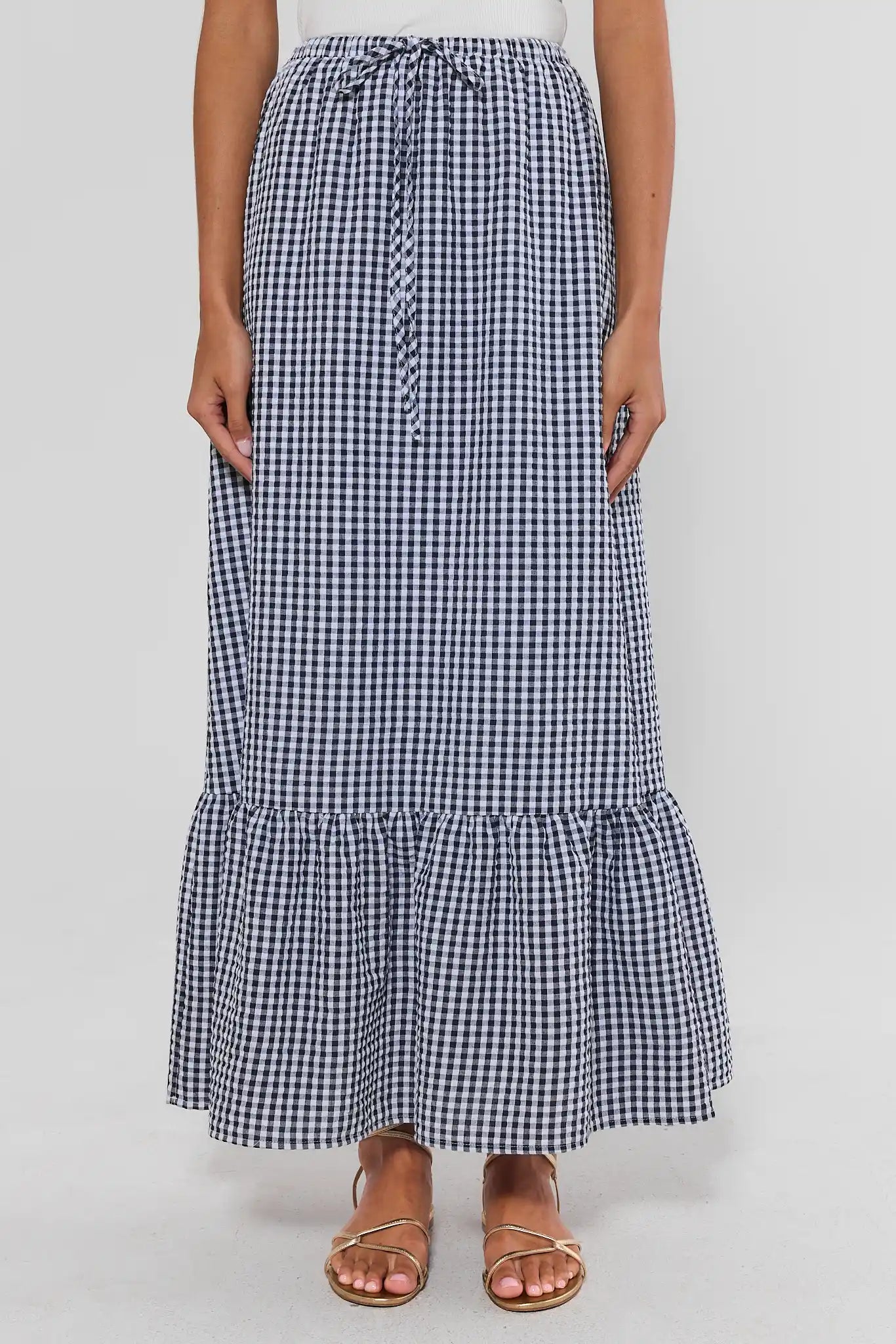 Woman wearing a black and white checkered skirt on a plain background