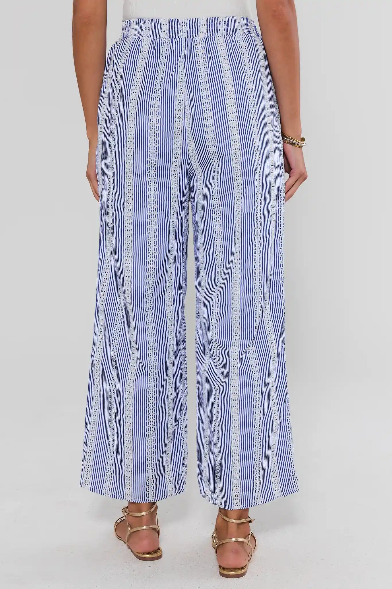 Blue and white striped pants worn by a person on a white background standing