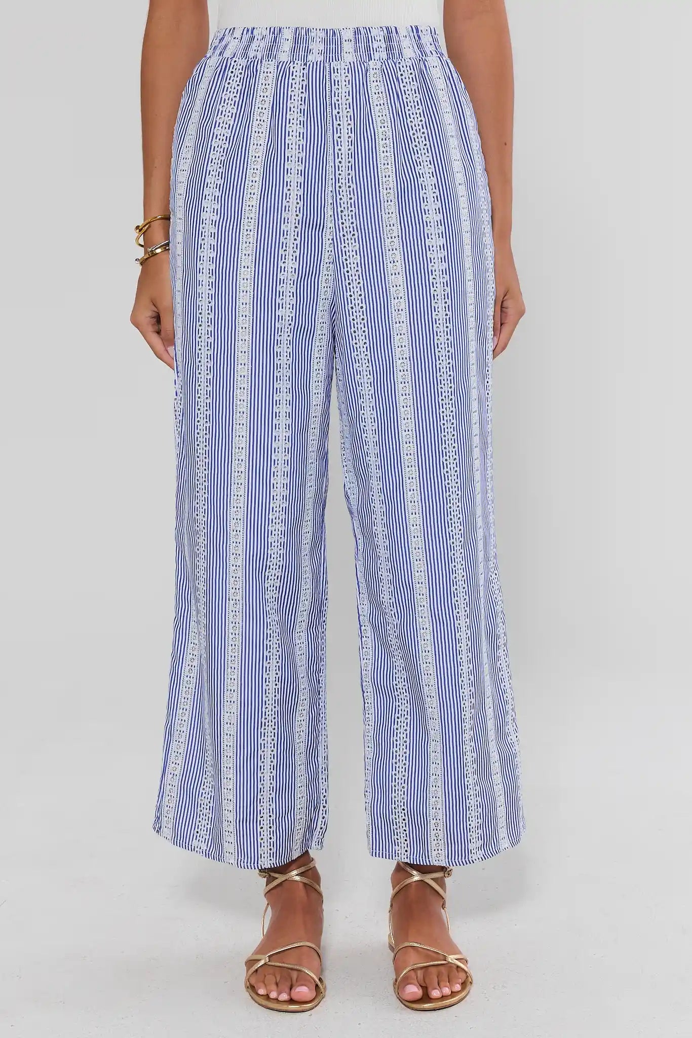 Blue and white striped pants worn by a person on a white background