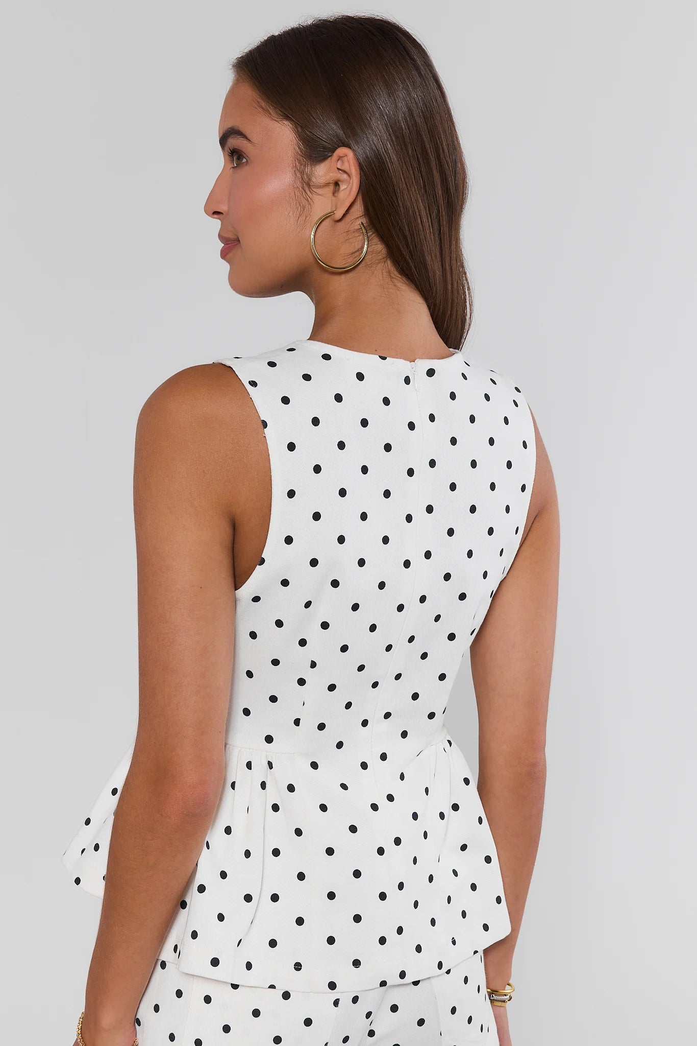 Woman wearing a polka dot outfit standing on a white background set