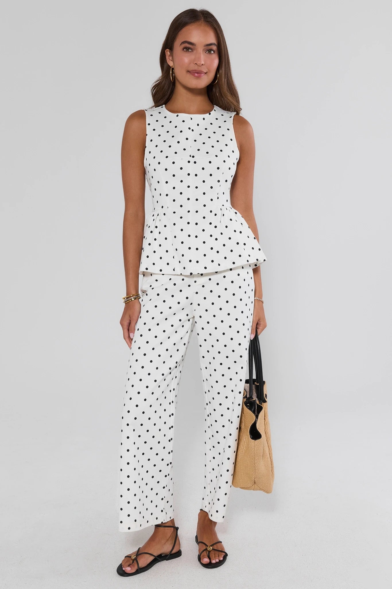 Woman wearing a polka dot outfit holding a bag on a white background set