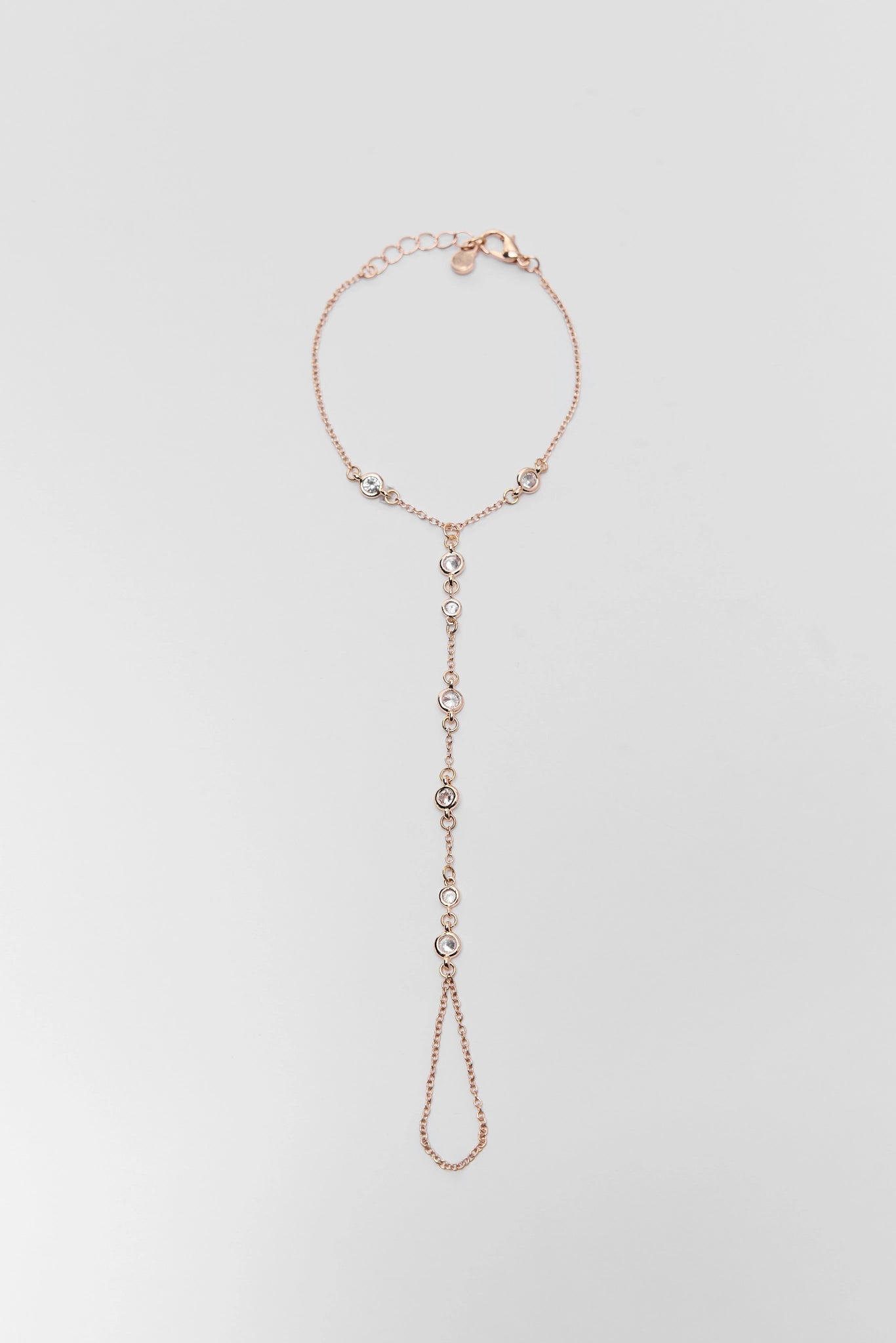 gold hand chain bracelet on a light gray background