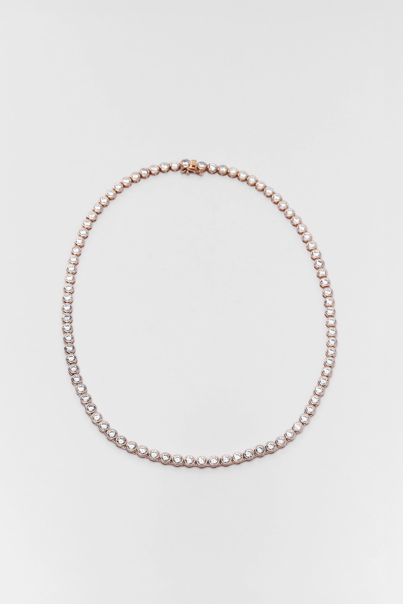 Tennis necklace on a light gray background