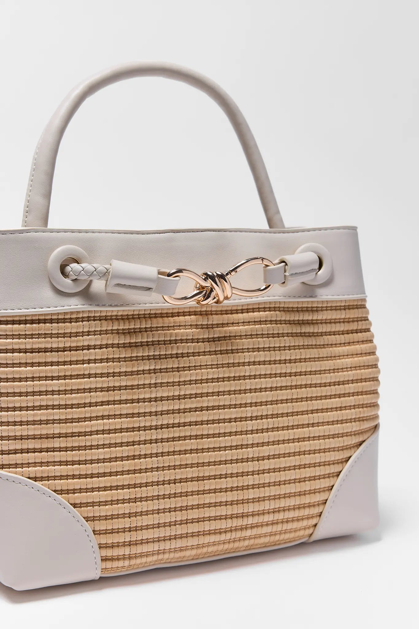 Handbag with beige woven pattern and light gray accents on a white background close up