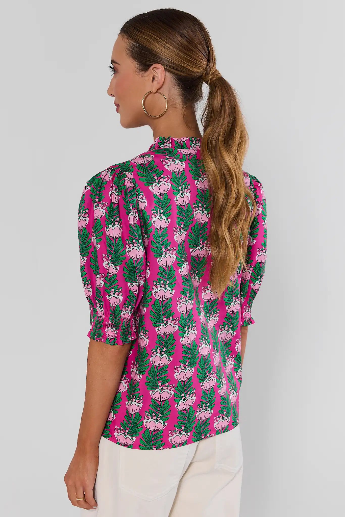 woman standing wearing amanda pink floral green top on white background