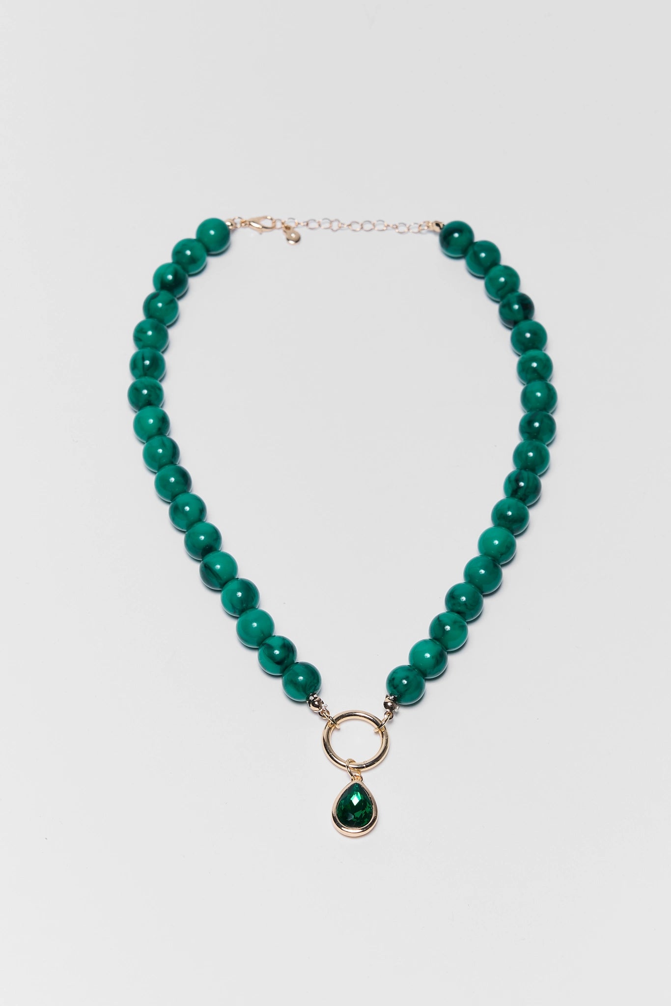 green beaded necklace on white background