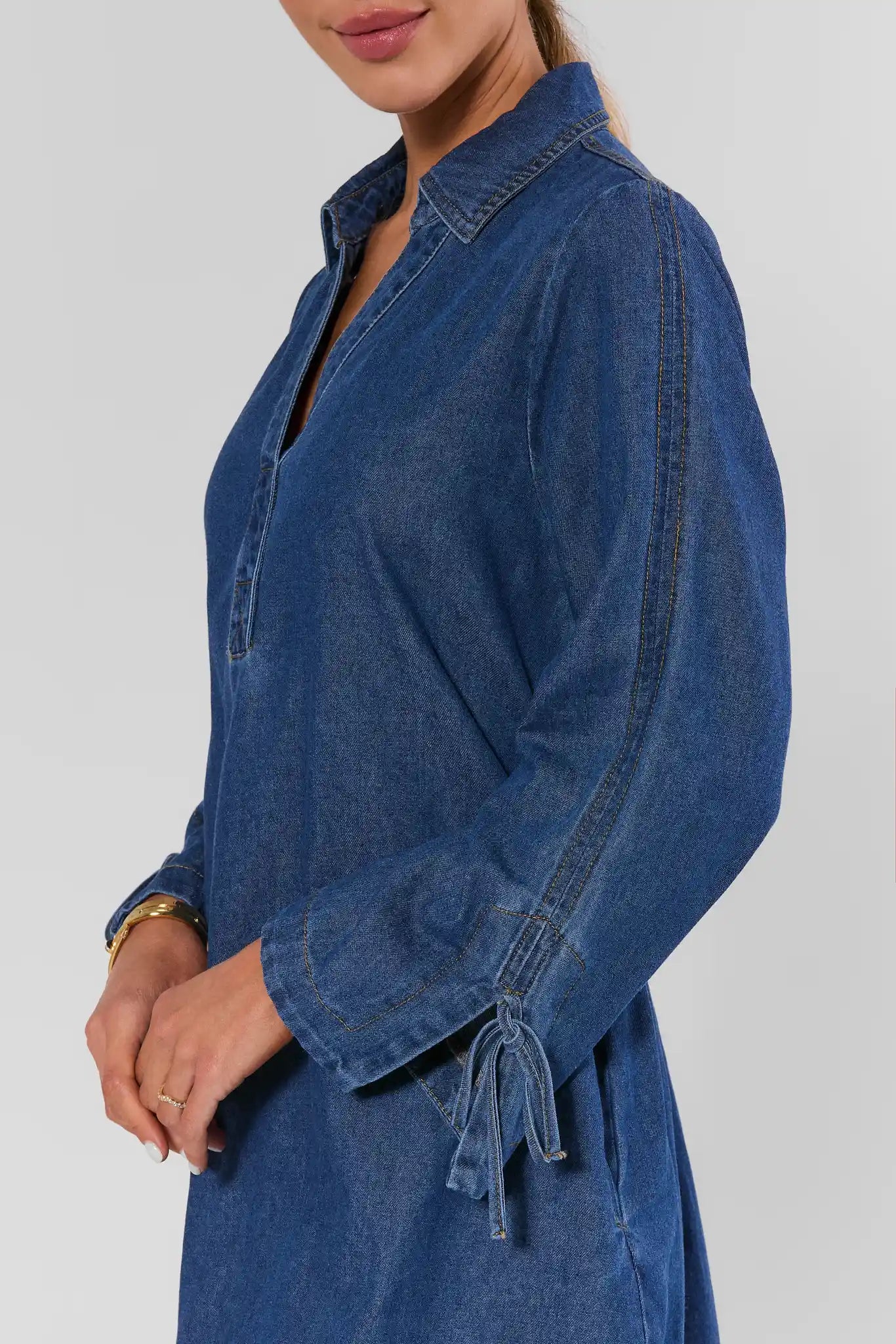 close up woman wearing shay denim mini dress on a white background