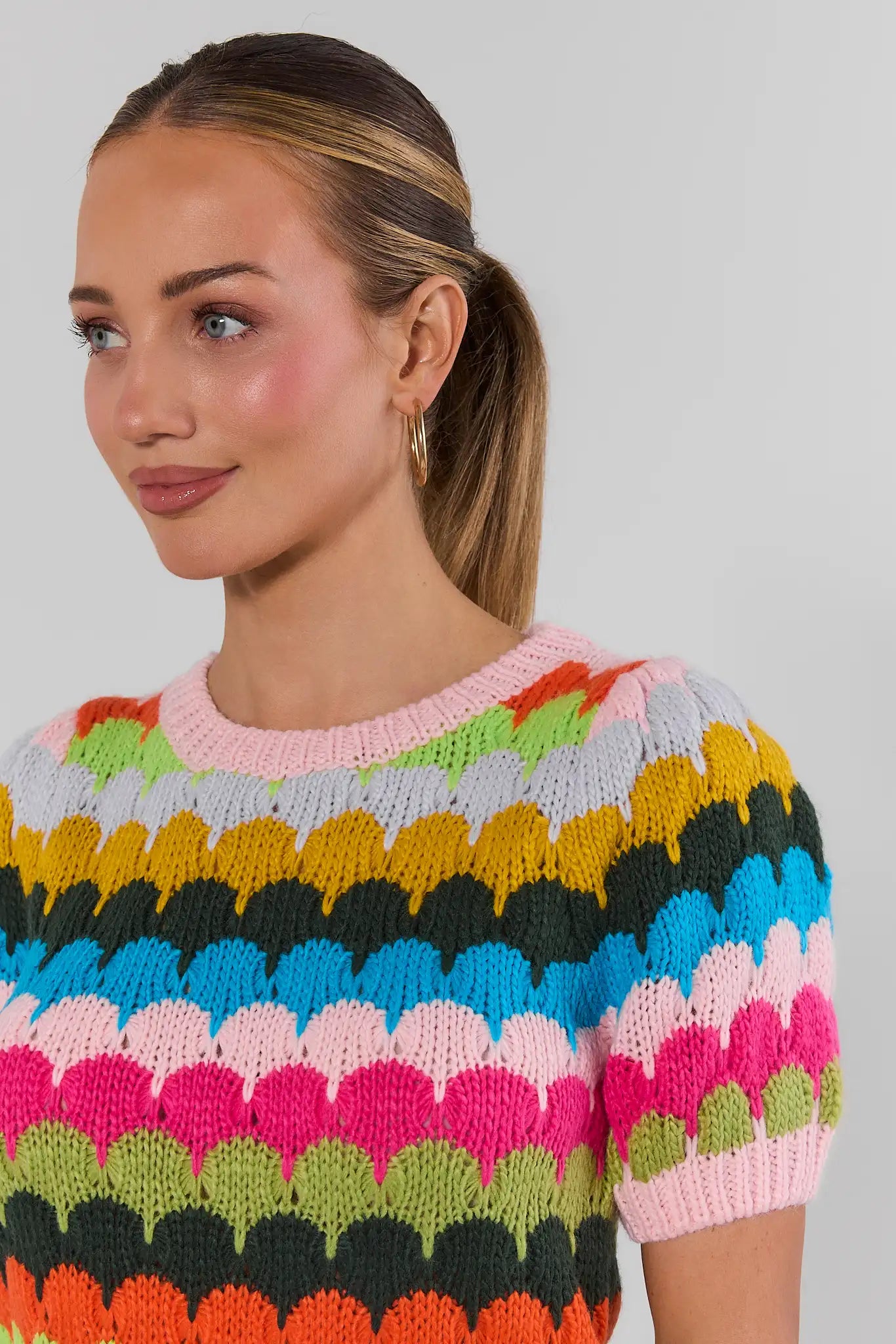 close up woman wearing trina multi striped knit top on a white background