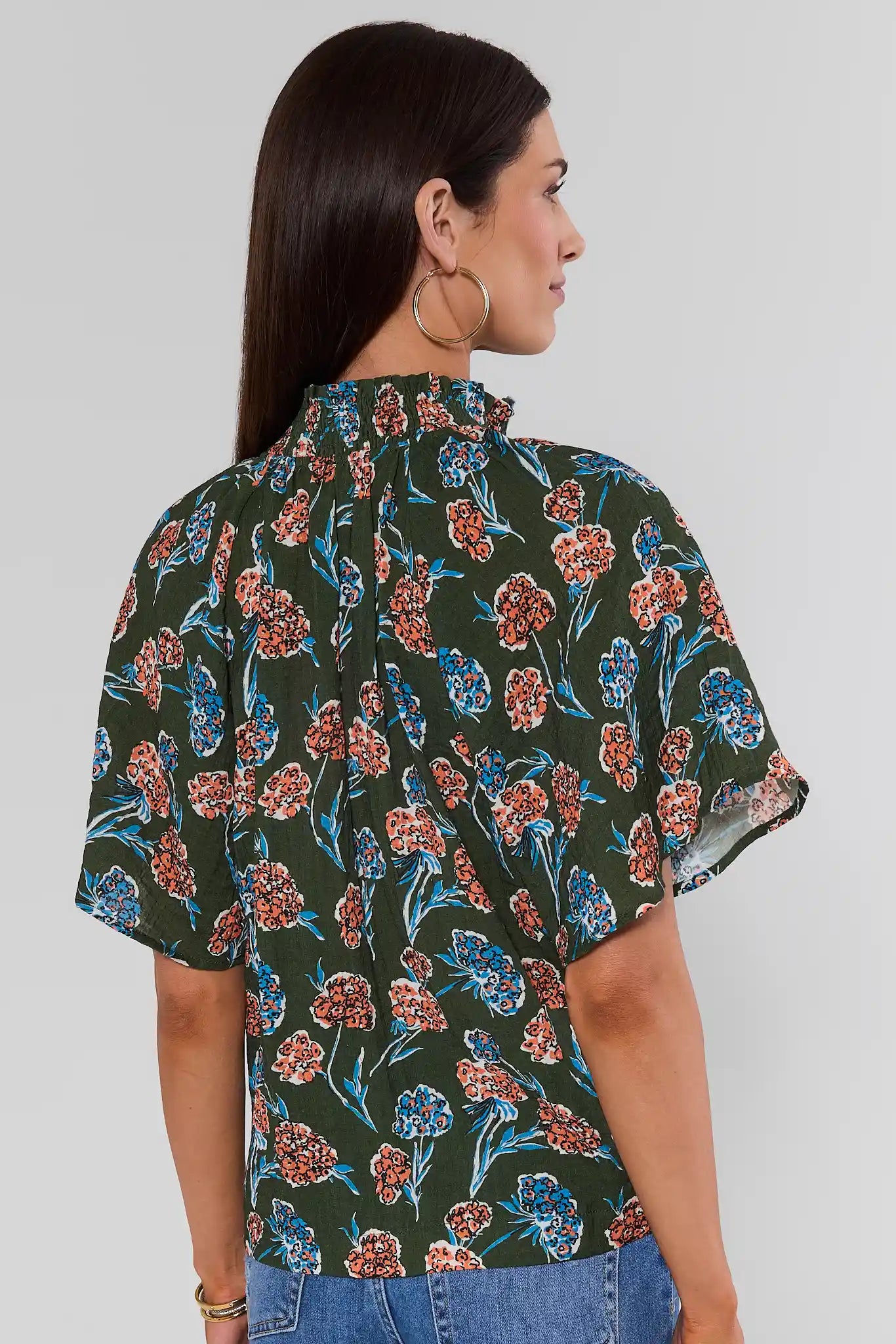 Woman wearing Macey Forest Green Floral Top by THML on a white background standing back