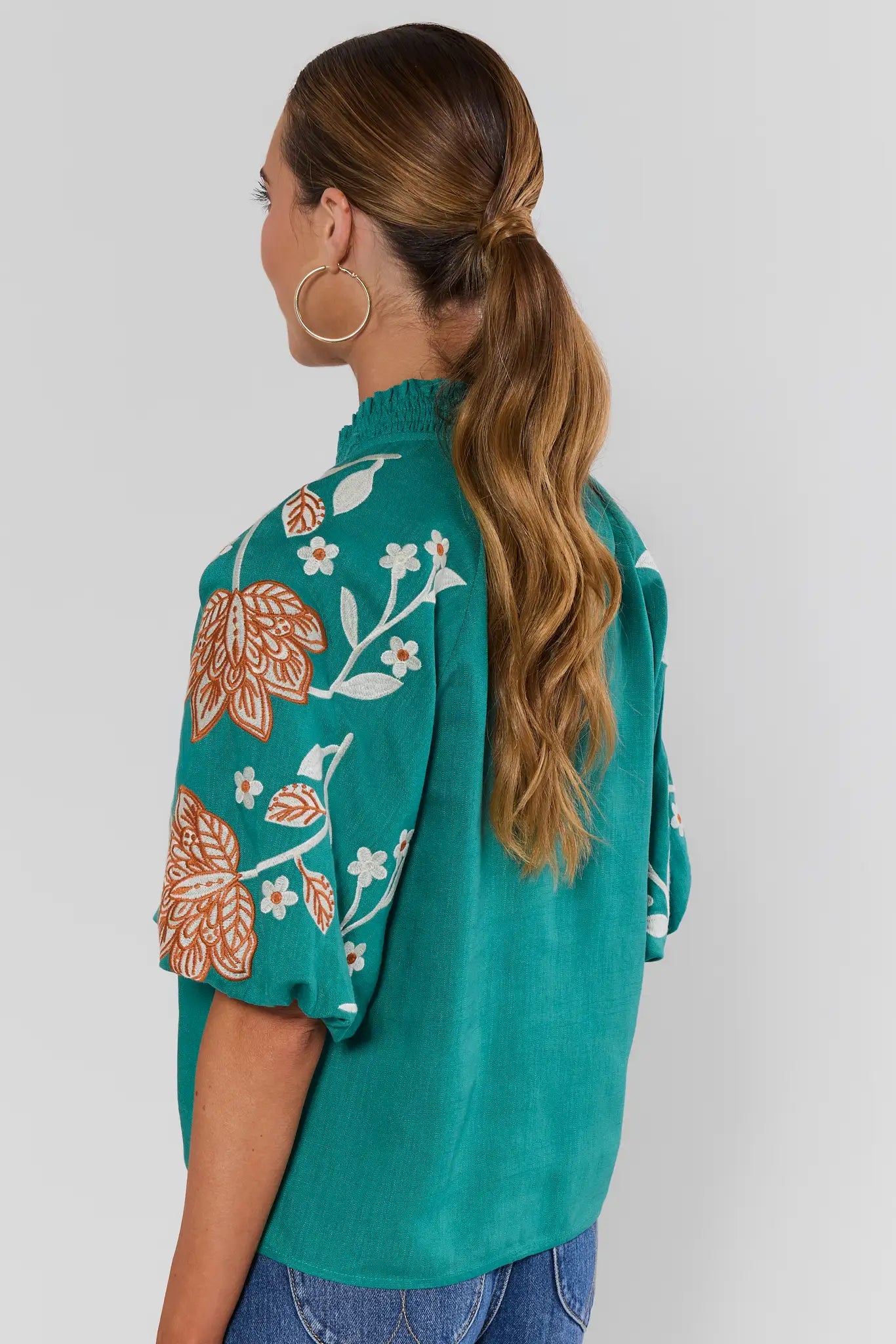 Woman wearing Emmett Green Floral Embroidered Top by THML on a white background standing