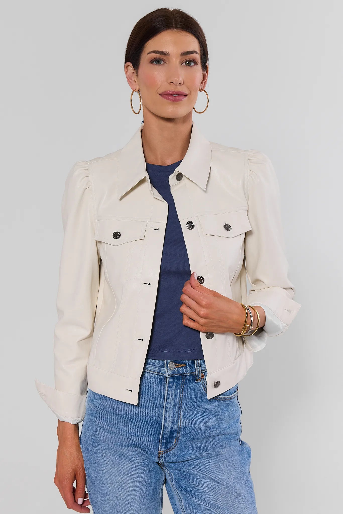 Woman wearing Roxanna Cream Faux Leather Jacket with jeans on a white background