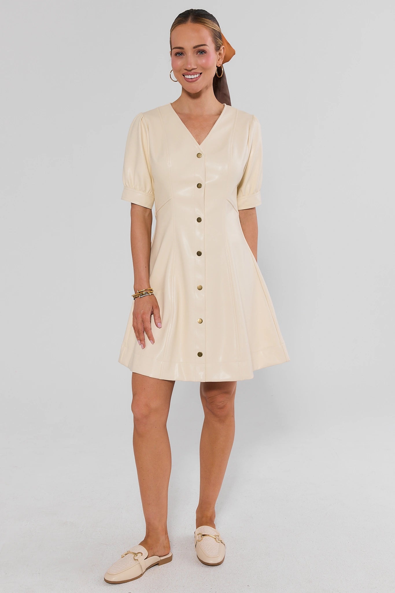 Woman standing wearing Ivory Faux Leather Short Dress and hair scarf on a white background