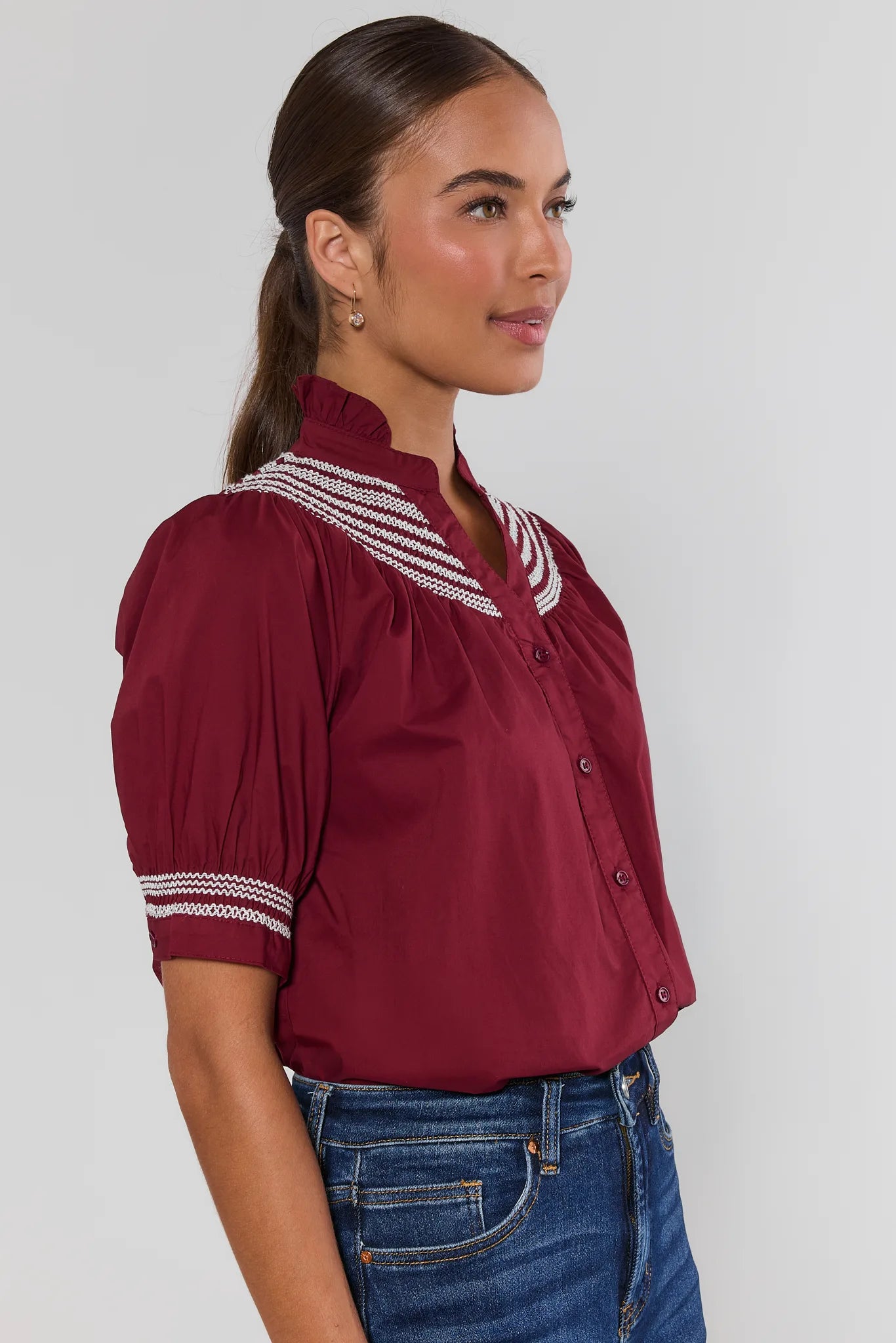 Woman wearing Yvonne Burgundy and White Embroidered Top on a white background side