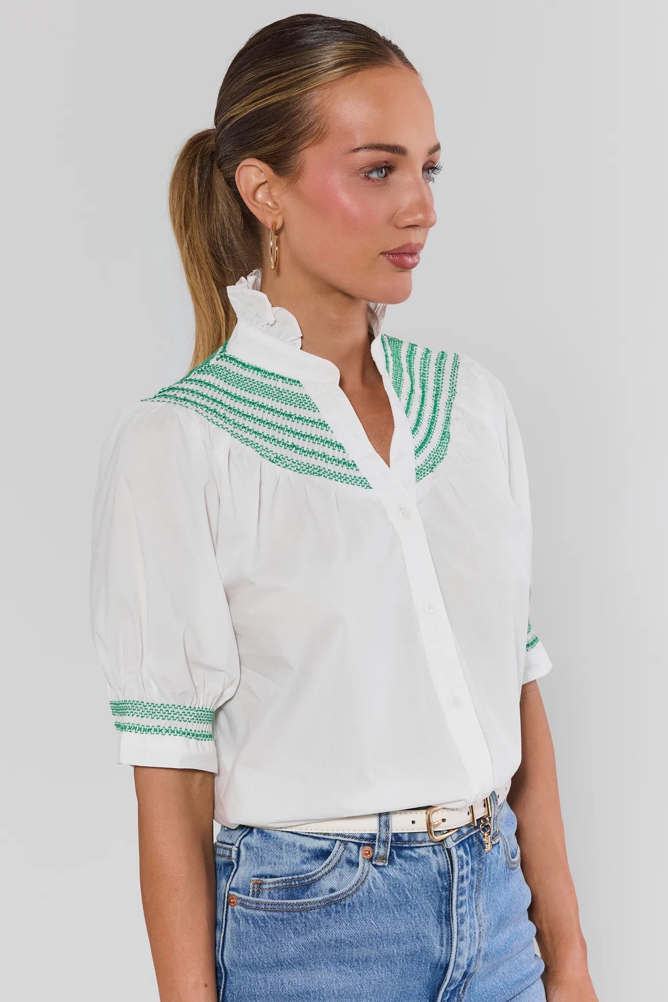 Woman wearing Yvonne White and Green Embroidered Top on a white background side