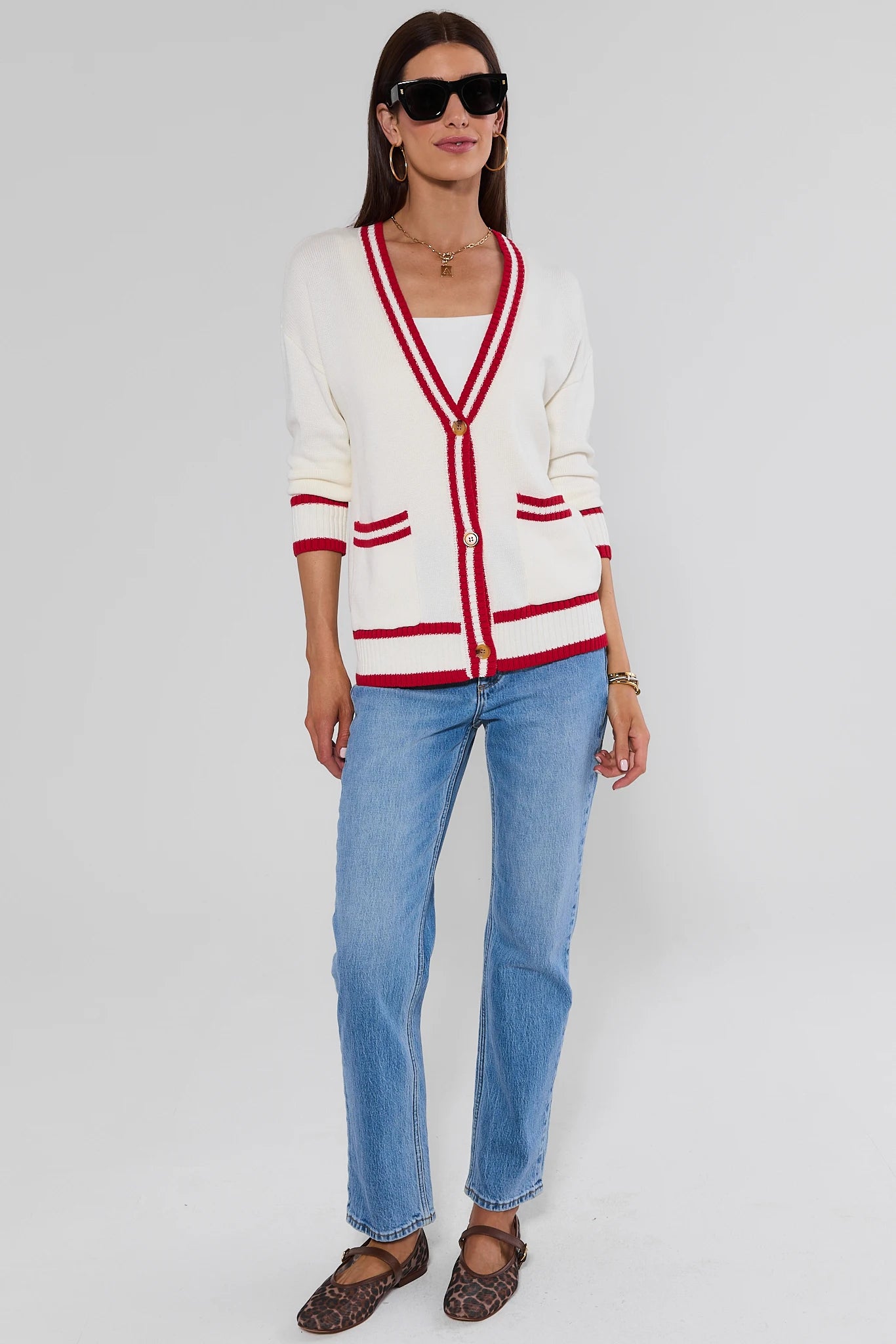 woman standing wearing Jenna Ivory Applique Cardigan and jeans on a white background 