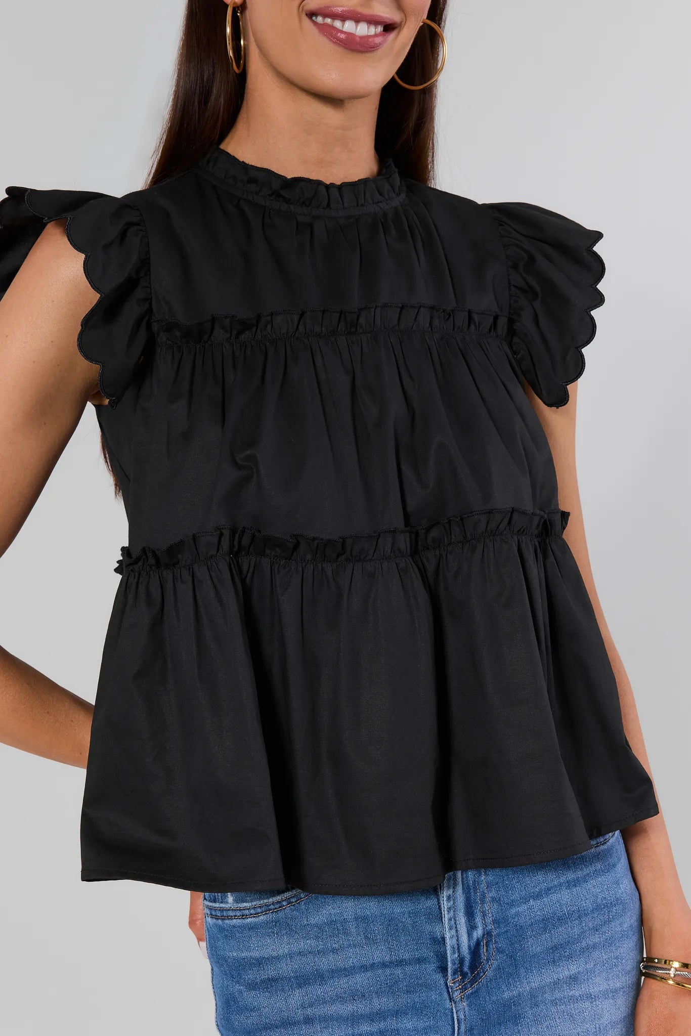 close up woman wearing Black Tiered Flutter Sleeve Top on a white background
