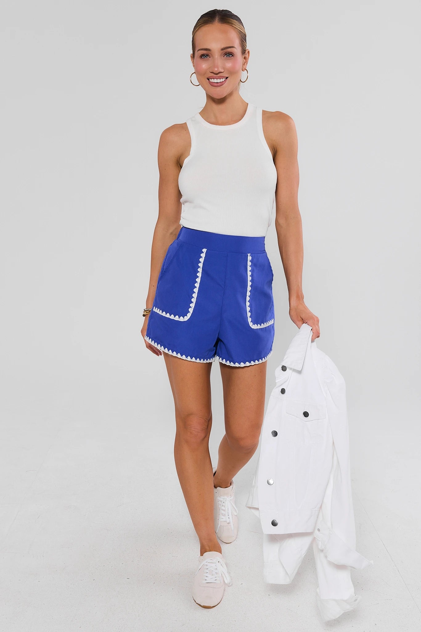 Woman walking wearing Blue Embroidered Trim Shorts on a white background